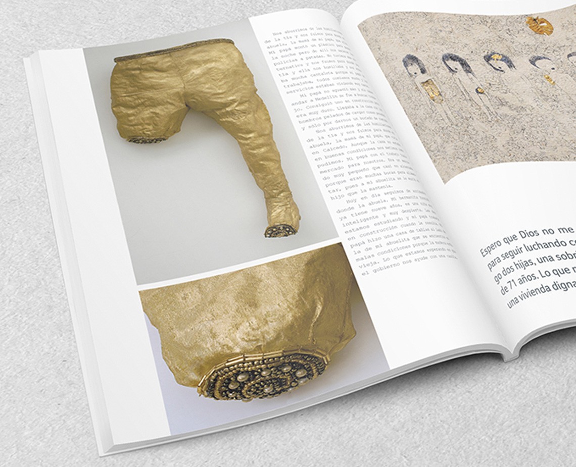 An open book displays two photographs of golden garments: one showing a leg and the other a torso. The text on the right page reads “Espero que Dios no me para seguir luchando sobre los hijos, una sobreviviente digna.”