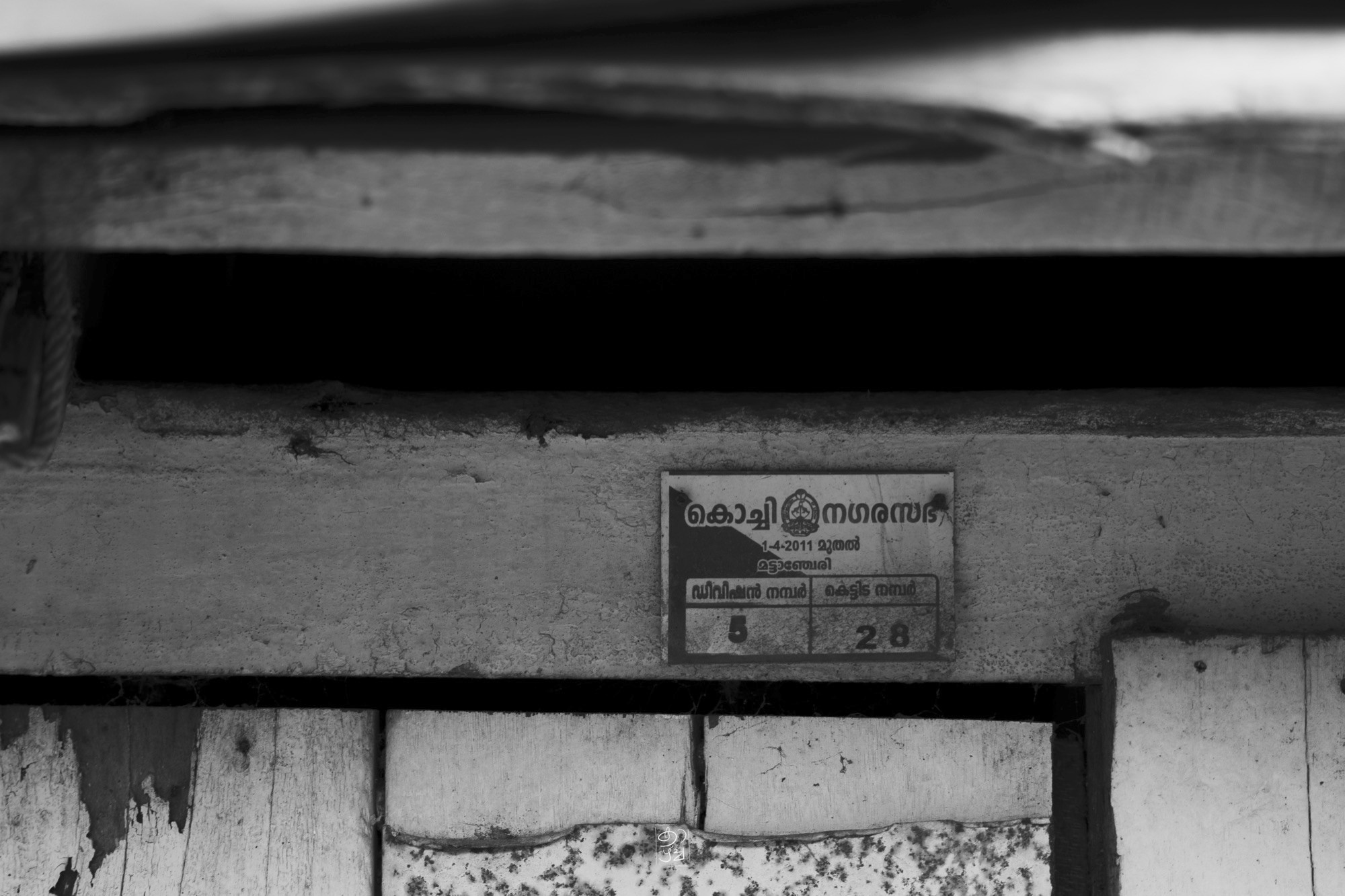 A painted shop sign above a closed shutter