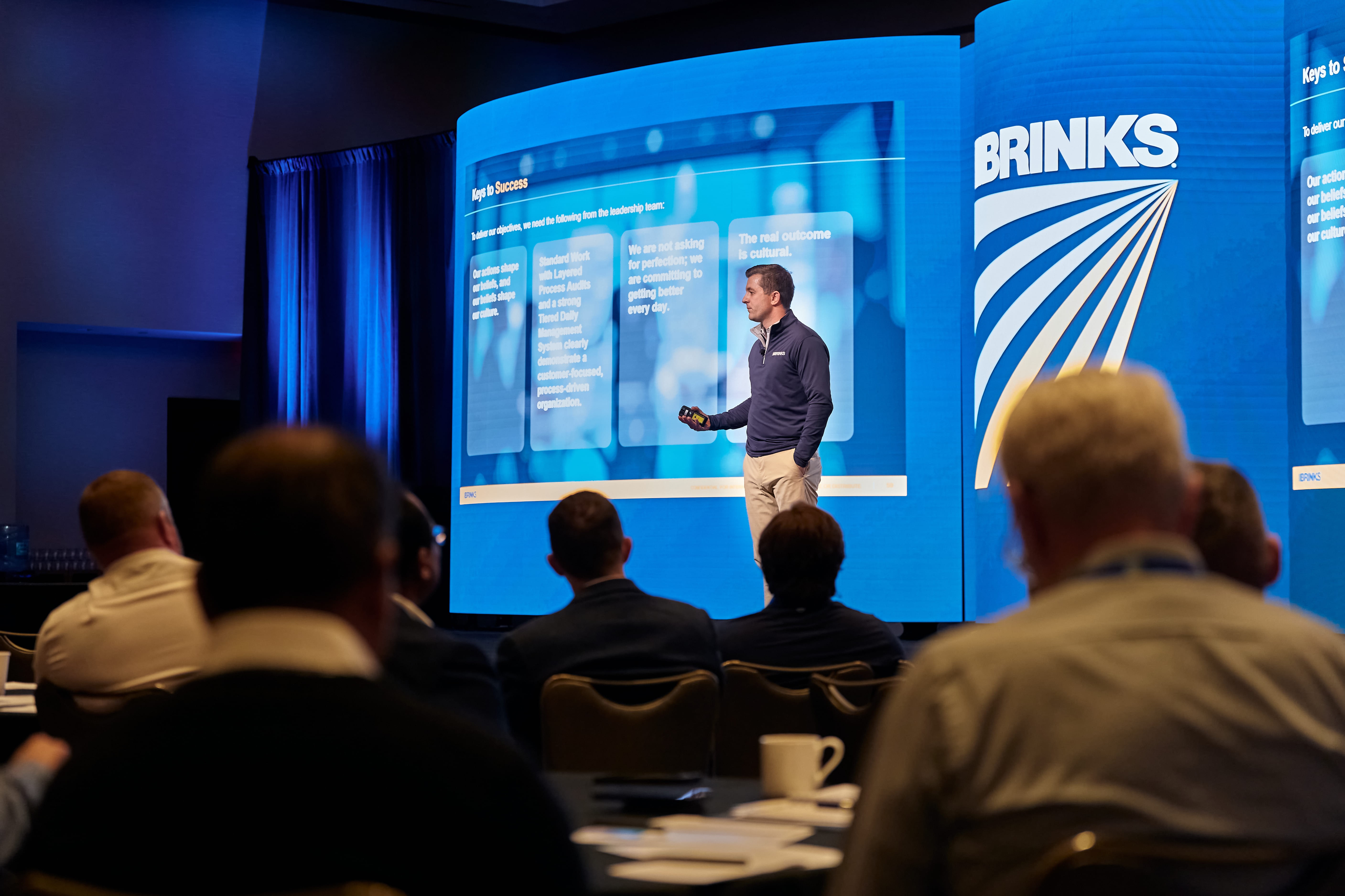 A neatly arranged set of gray office supplies on a gray surface, featuring notepads, a smartphone, pens, and a colorful gradient book cover, conveying a sleek, modern vibe.
