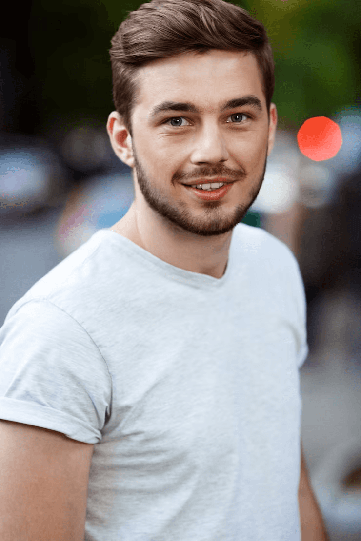 Profile portrait of a man in a white shirt against a light background