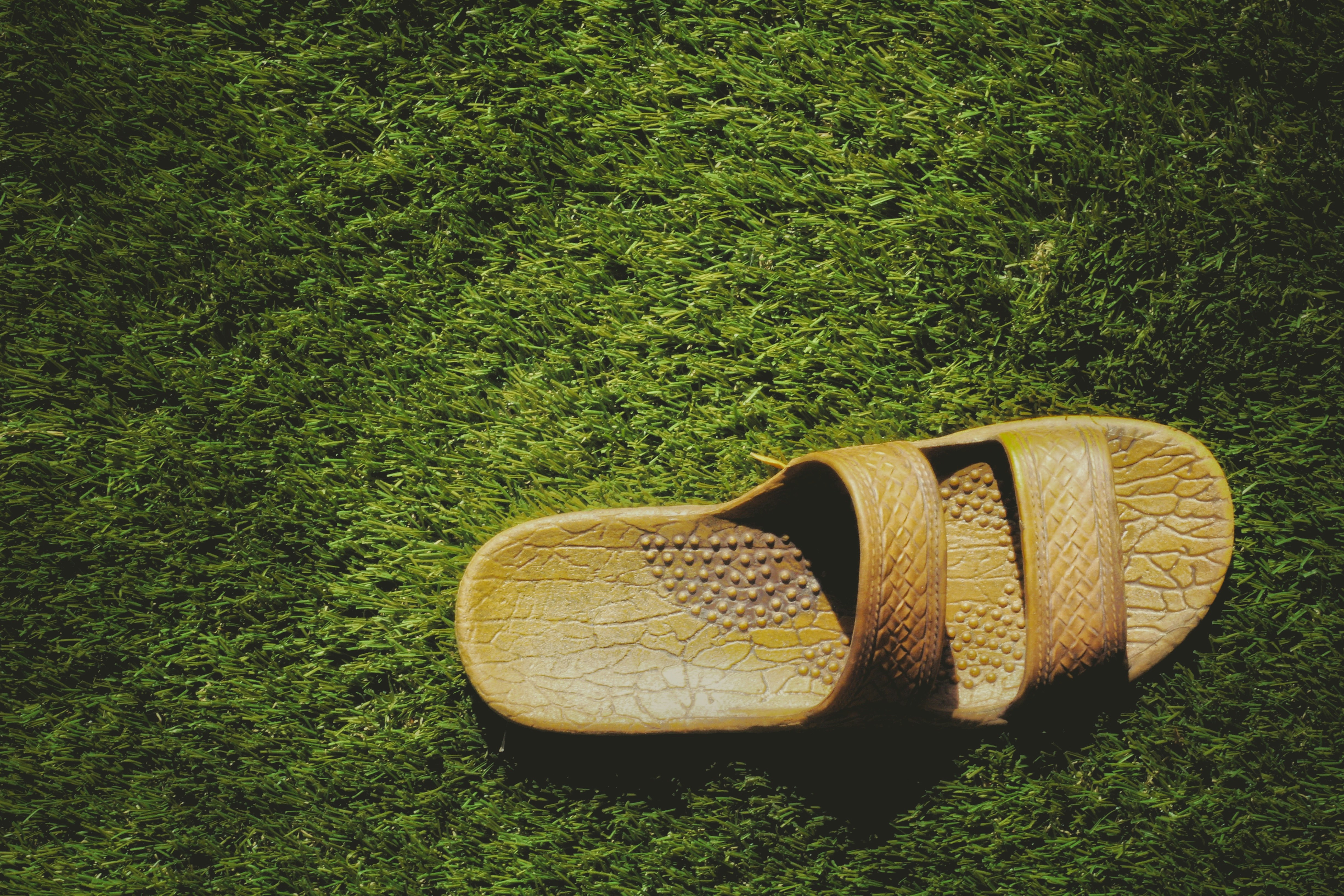brown slide sandals on green textile