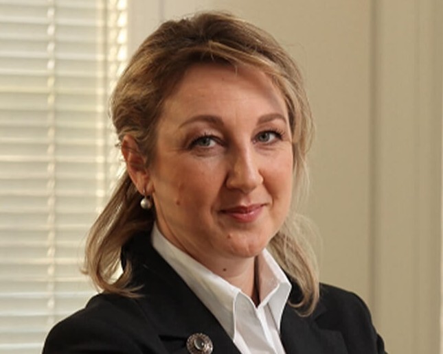 Profile portrait of a man in a white shirt against a light background