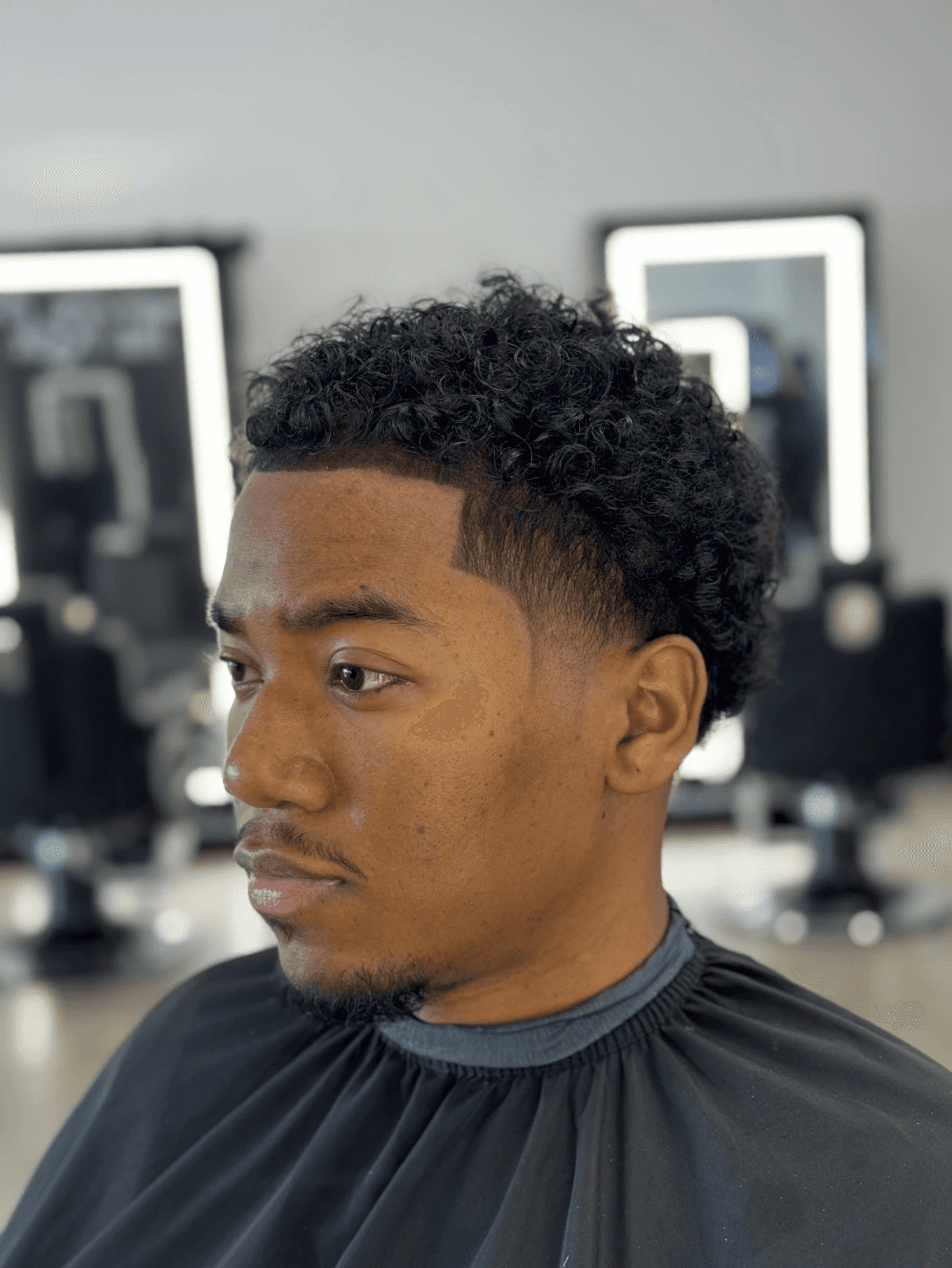 Classic mid taper fade for men, highlighting a natural hairline and youthful styling by Courtney Palmore.