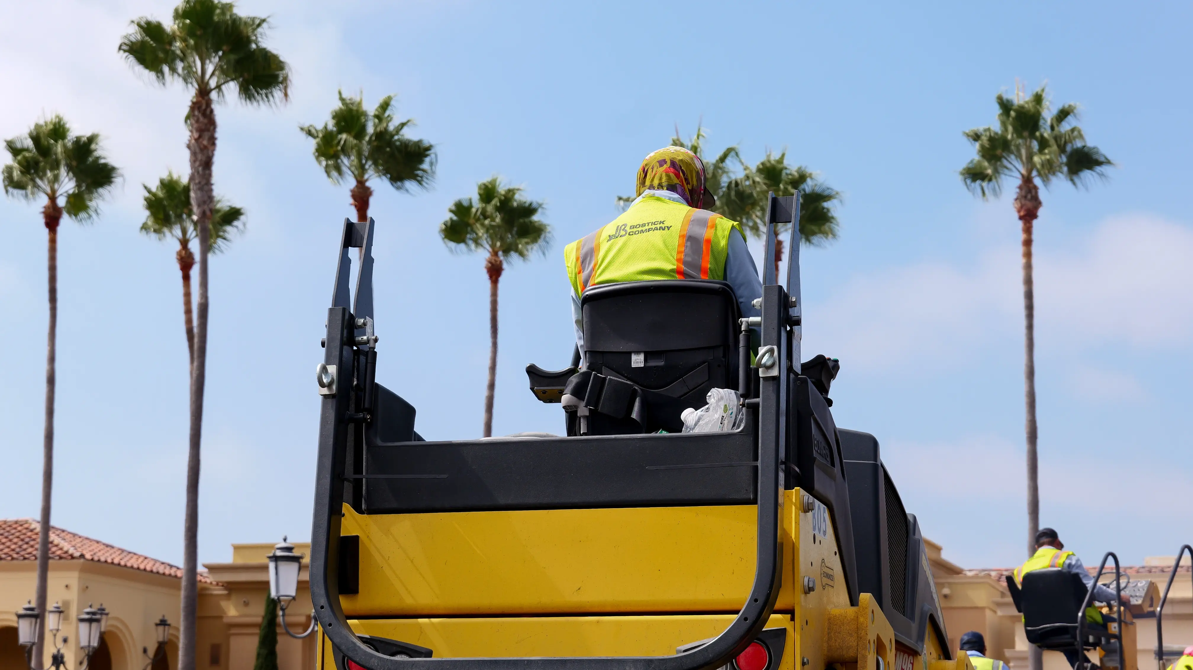 Rolling machine compressing new asphalt pavement on project