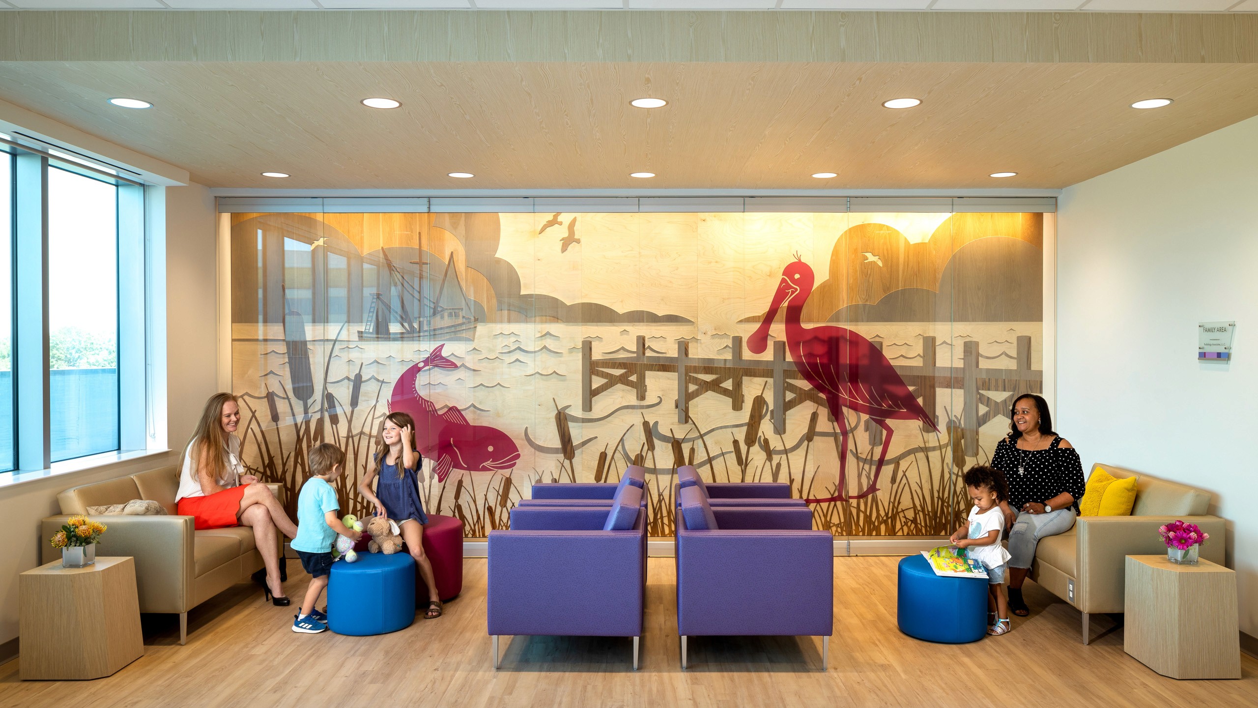 Family waiting area with art mural and seating.