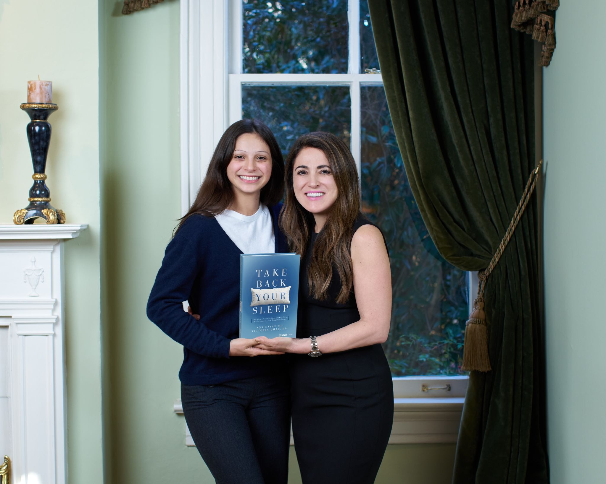Mother-daughter authors pose with “Take Back Your Sleep” book promoting neuroscience, deep sleep, and brain longevity.
