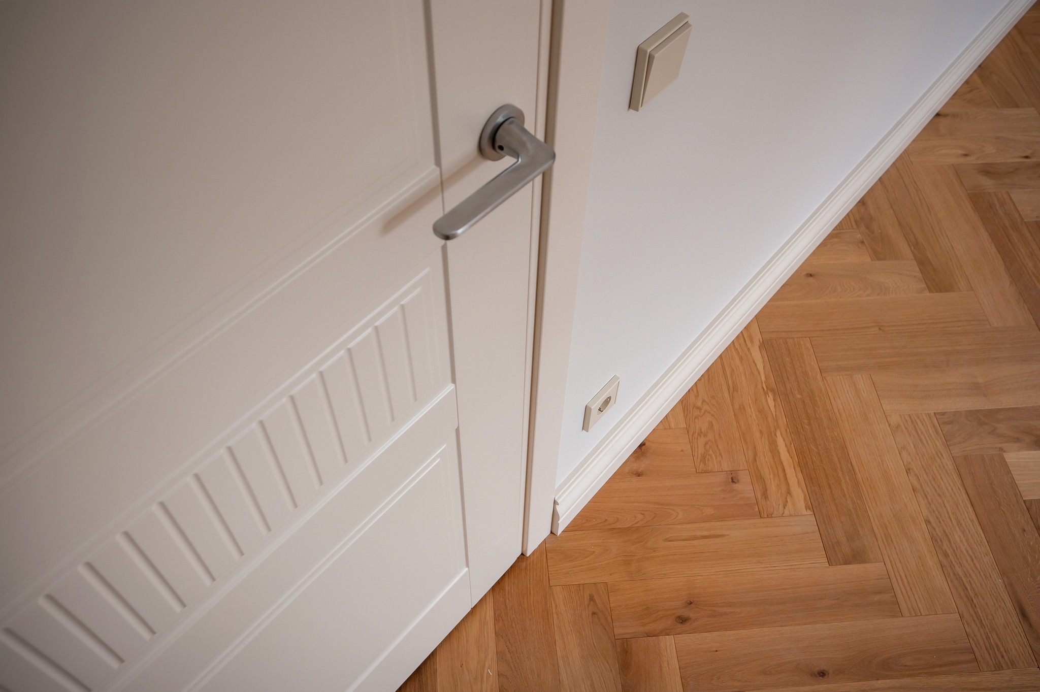 A minimalist white, modern beachside villa complex featuring extensive use of light-colored wood for pergolas, railings, and doors, situated in a row.