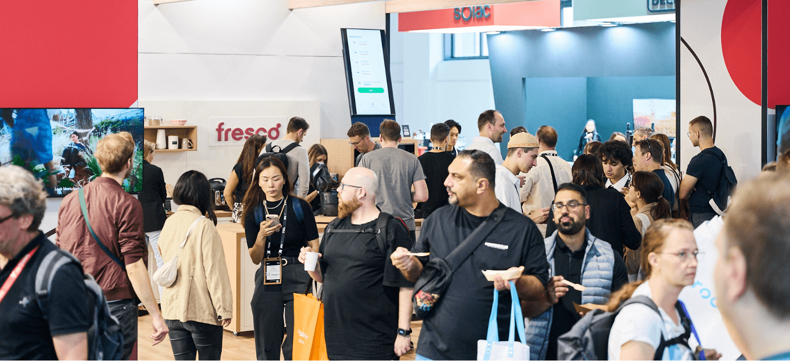 Crowd gathers at a Fresco booth during a busy trade show, with people exploring smart kitchen technology and connected cooking solutions