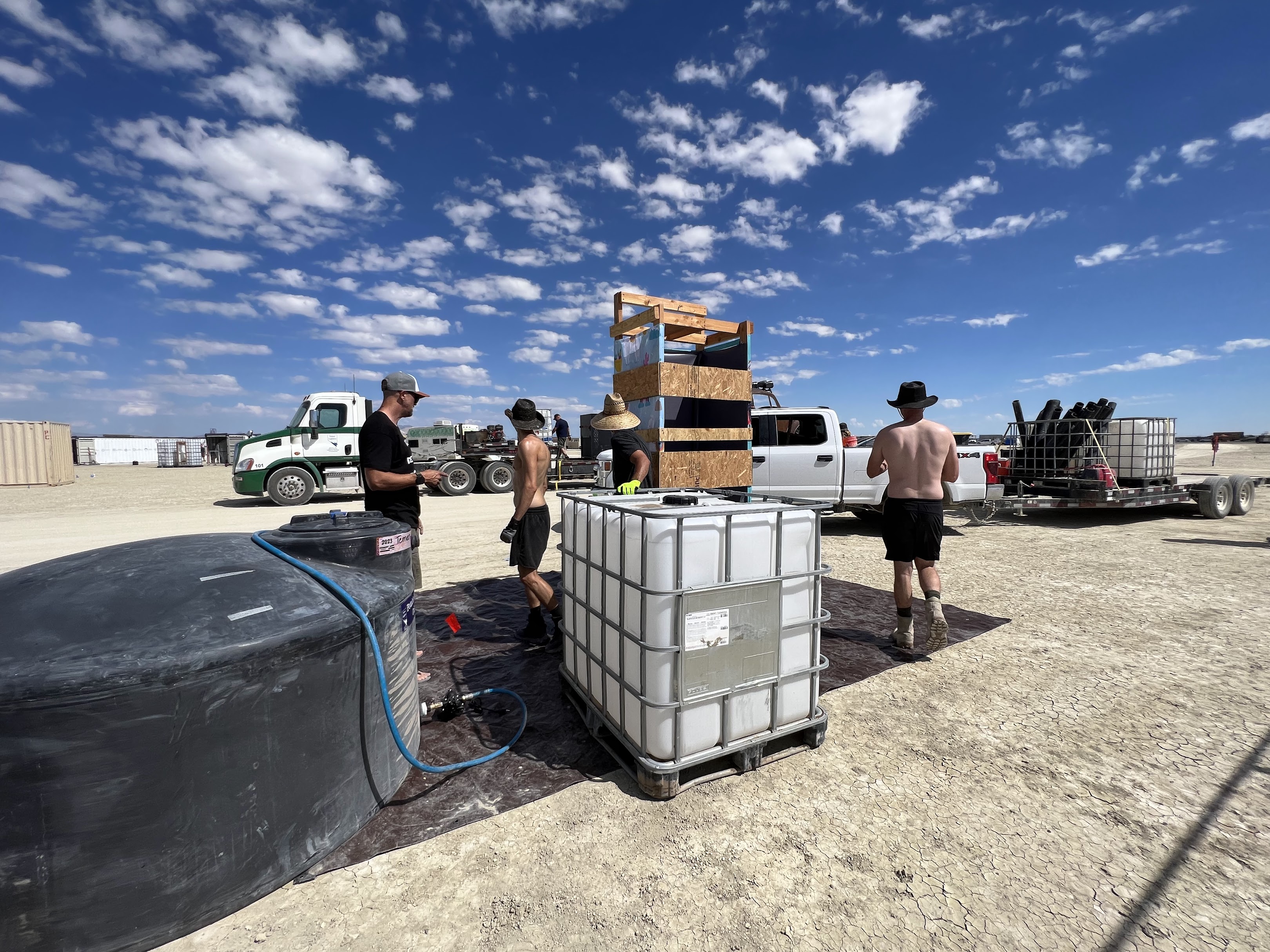 Camp members using water tanks and hoses for washing and cleaning
