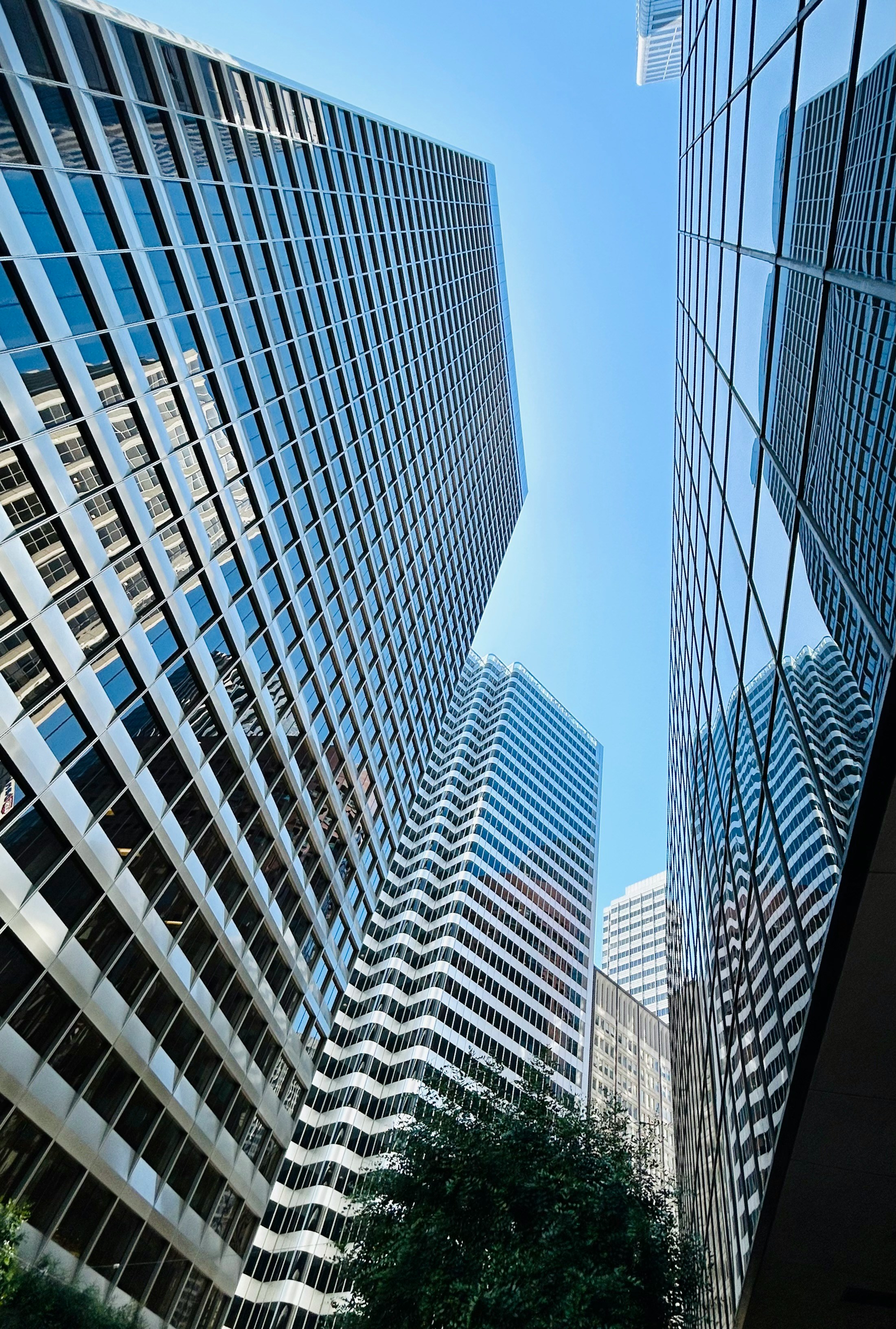 Skyscrapers reach high into a bright blue sky.