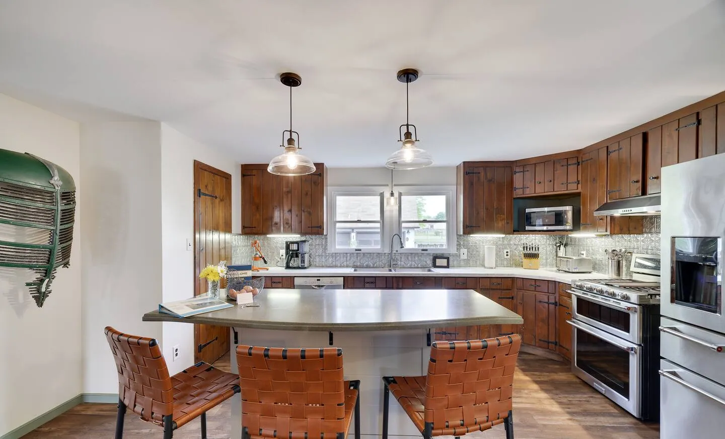 Kitchen island with leather stools, wood cabinets and stainless appliances at Rocking Horse Acres