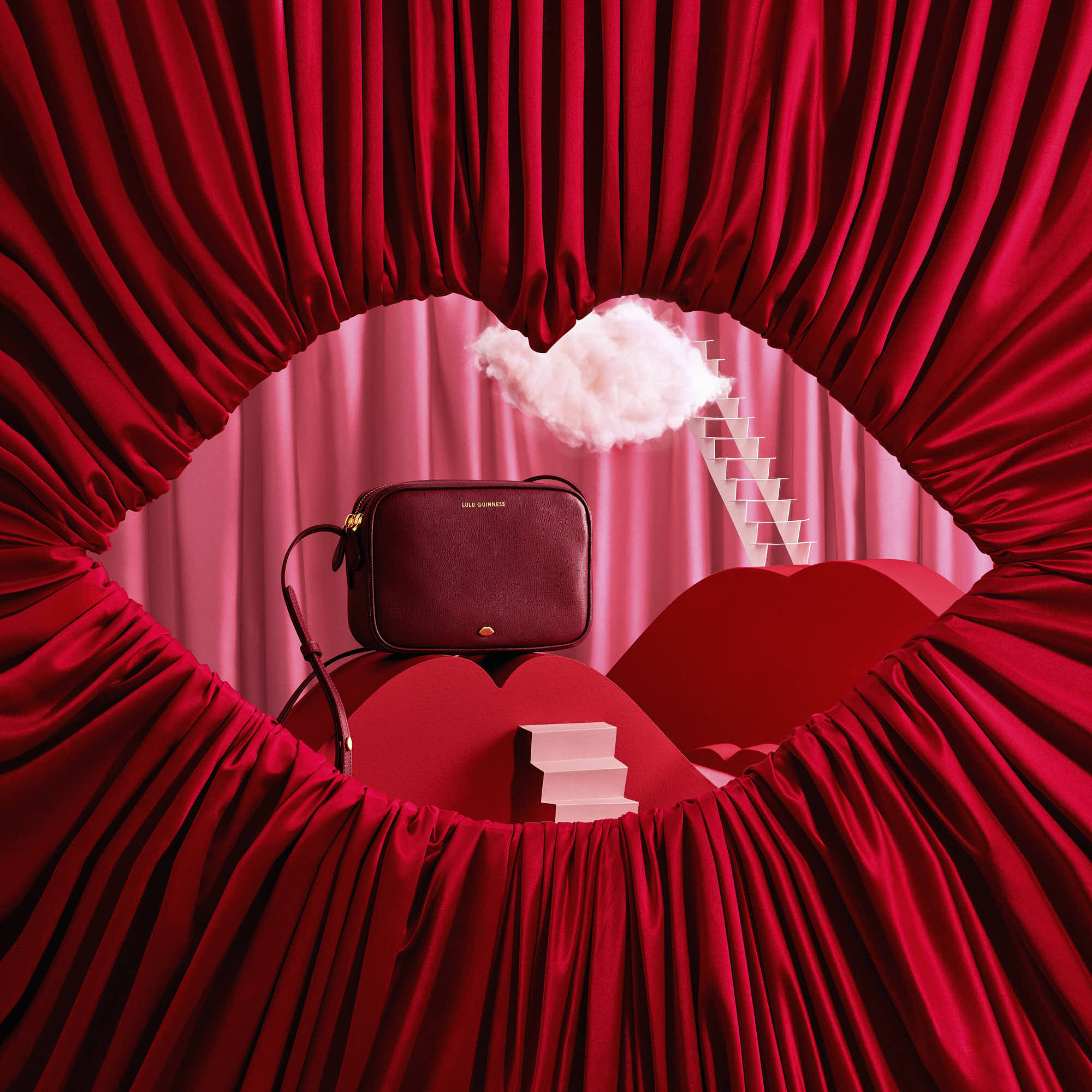Luxury red handbag with artistic backdrop and bold fabric drapes, modern fashion display.