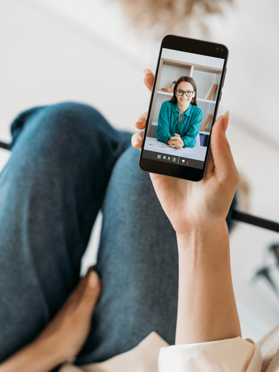 A woman's hand is holding a smartphone, displaying a video on its screen