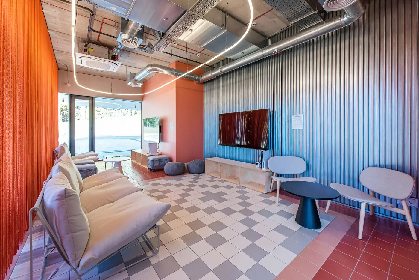 Student social lounge in Vilnius accommodation with sofas, television and casual seating areas.
