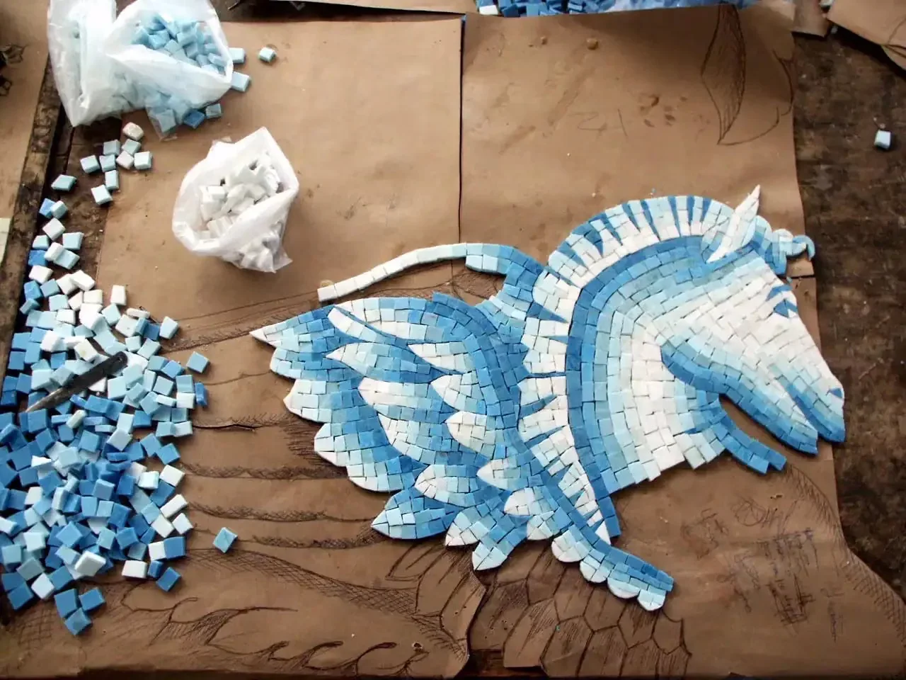 A hippocampus mosaic taking shape, hand-cut smalti laid over the working drawing.