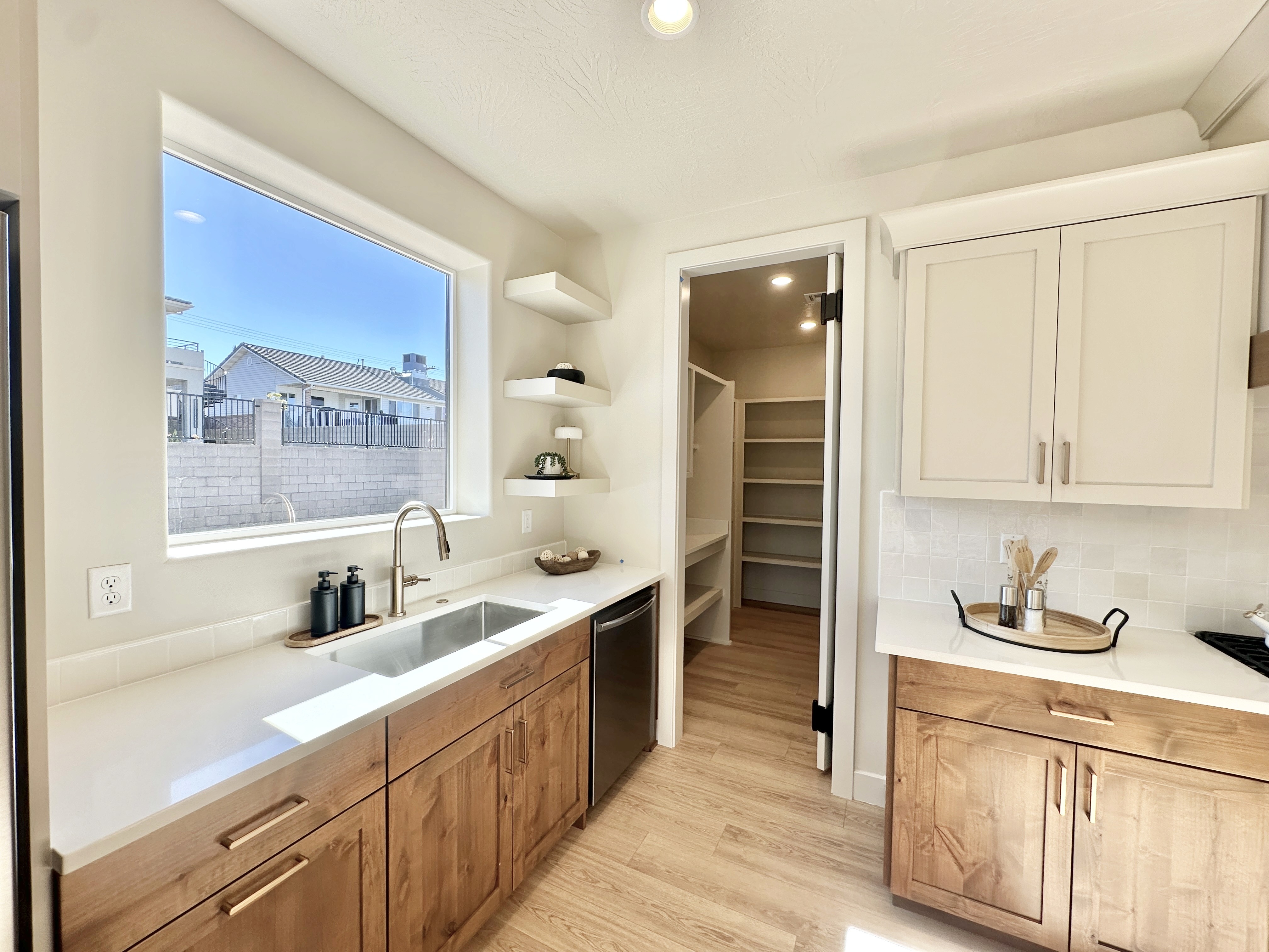 Butler’s pantry in a Southern Utah custom home with two-tone shaker-style cabinets and open shelves, combining style and functional storage.