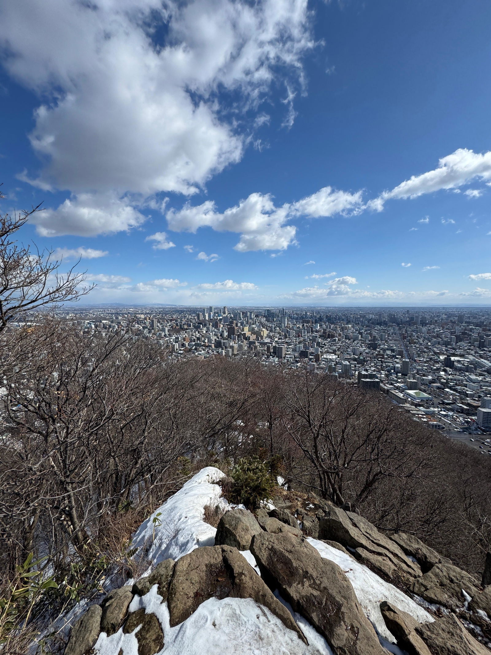 Snow-patched mountain viewpoint looking out over downtown Sapporo, Hokkaido