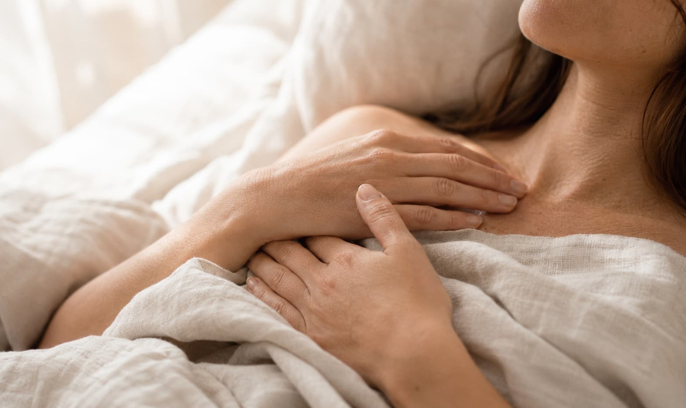 Close-up of hands resting gently over the chest, illustrating body awareness and listening as the foundation of sex drive