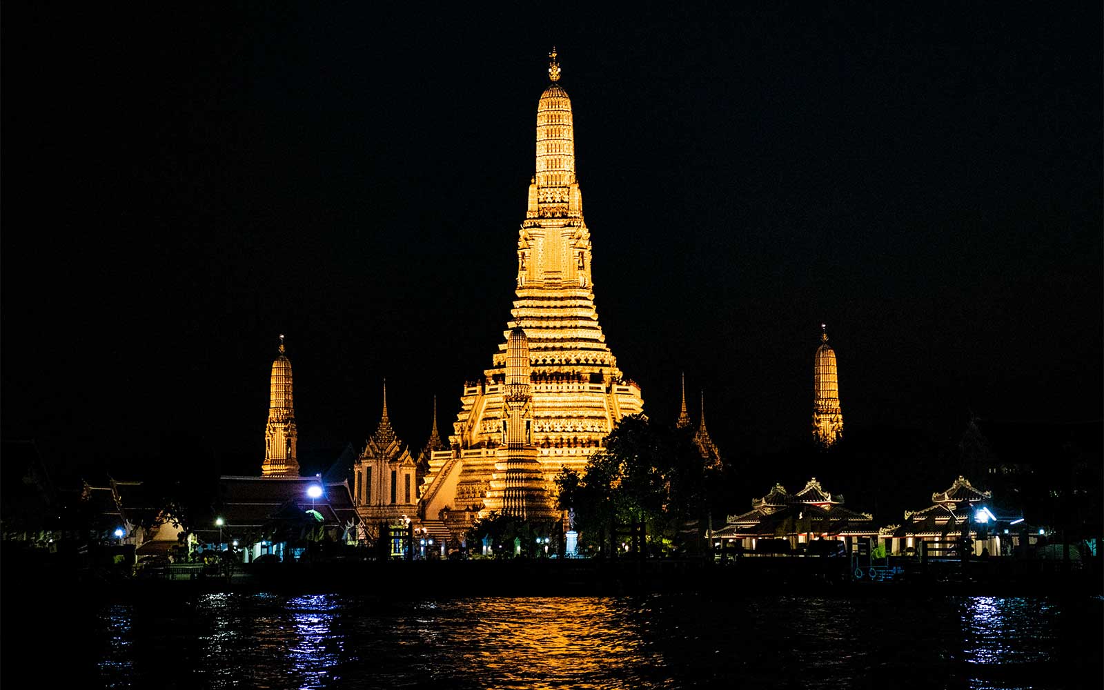 Wat Arun oświetlone nocą widziane z rzeki Chao Phraya, Bangkok.