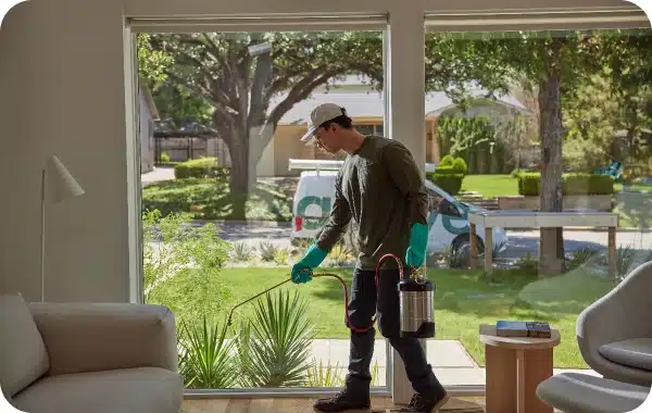 Pest control technician servicing the inside of a home