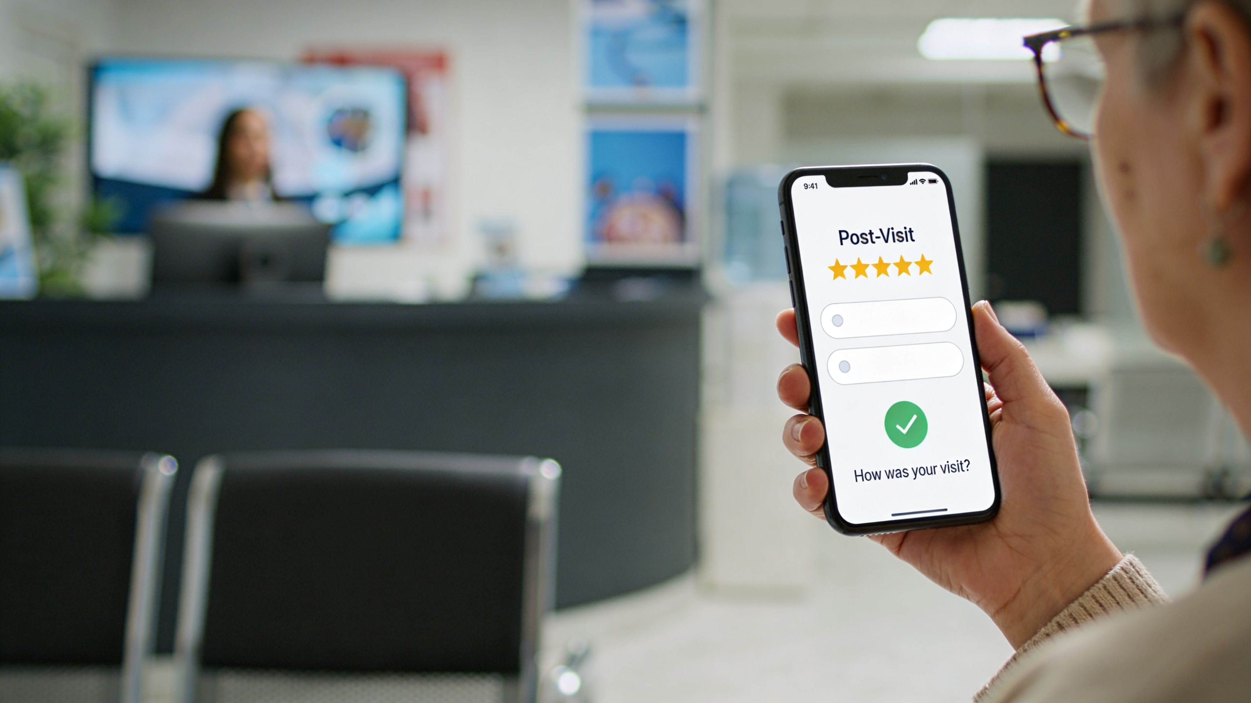 A patient holding a smartphone and filling out a medical practice post-visit feedback survey while in the lobby.