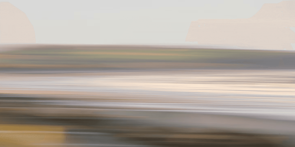 Motion-blurred landscape photograph with soft horizontal bands of color