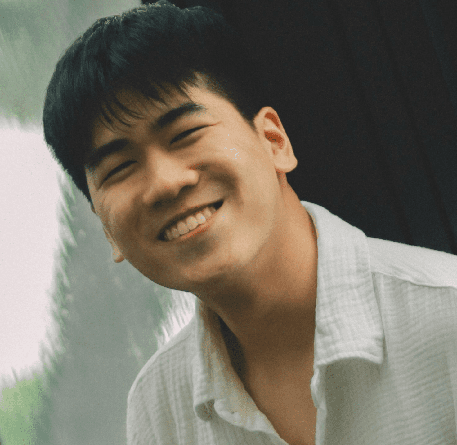 Smiling man in white shirt and tan pants