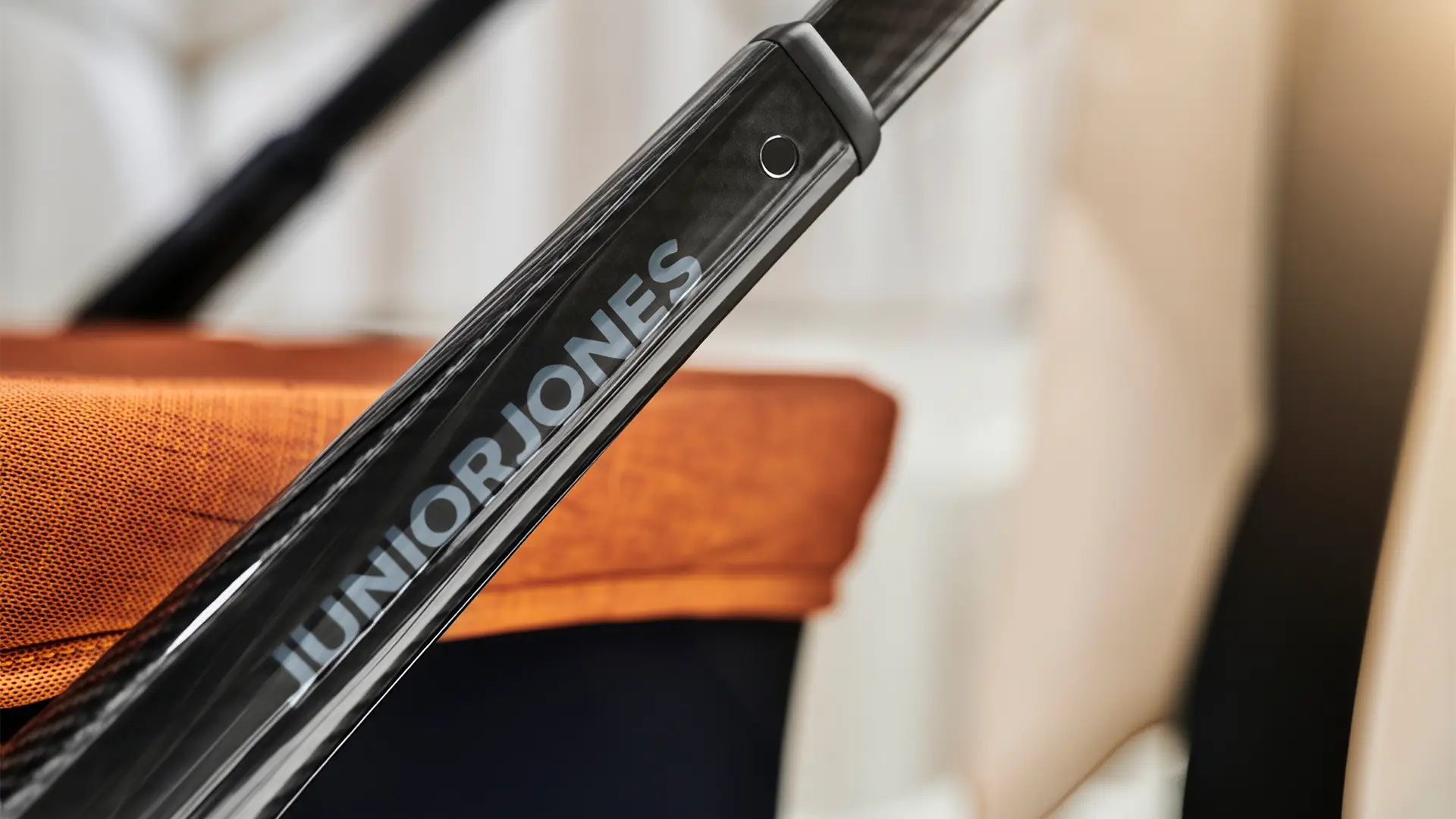 Close-up detail of the JUNIORJONES logo printed on the black stroller frame.