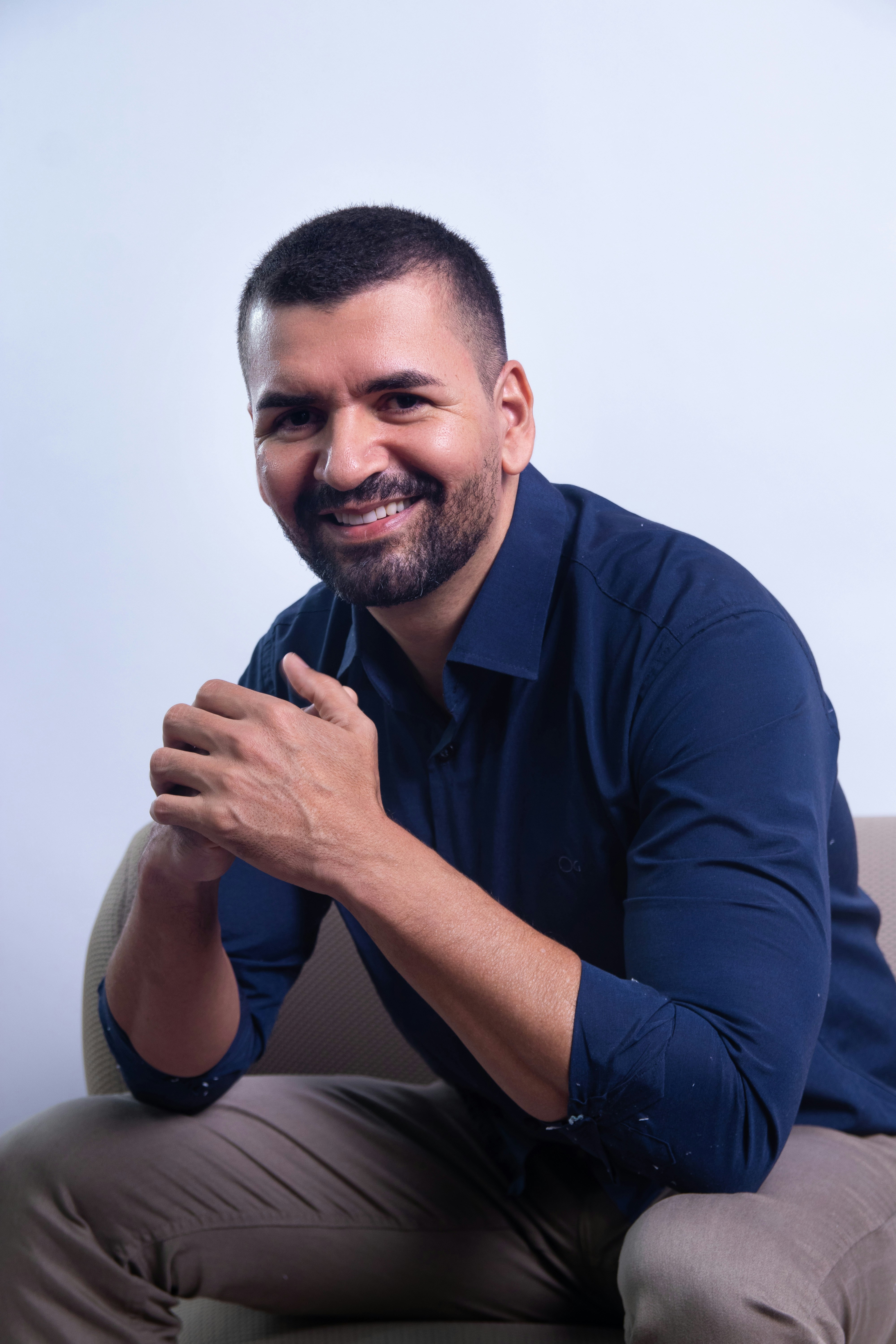 Man sitting on a chair, smiling at the camera.