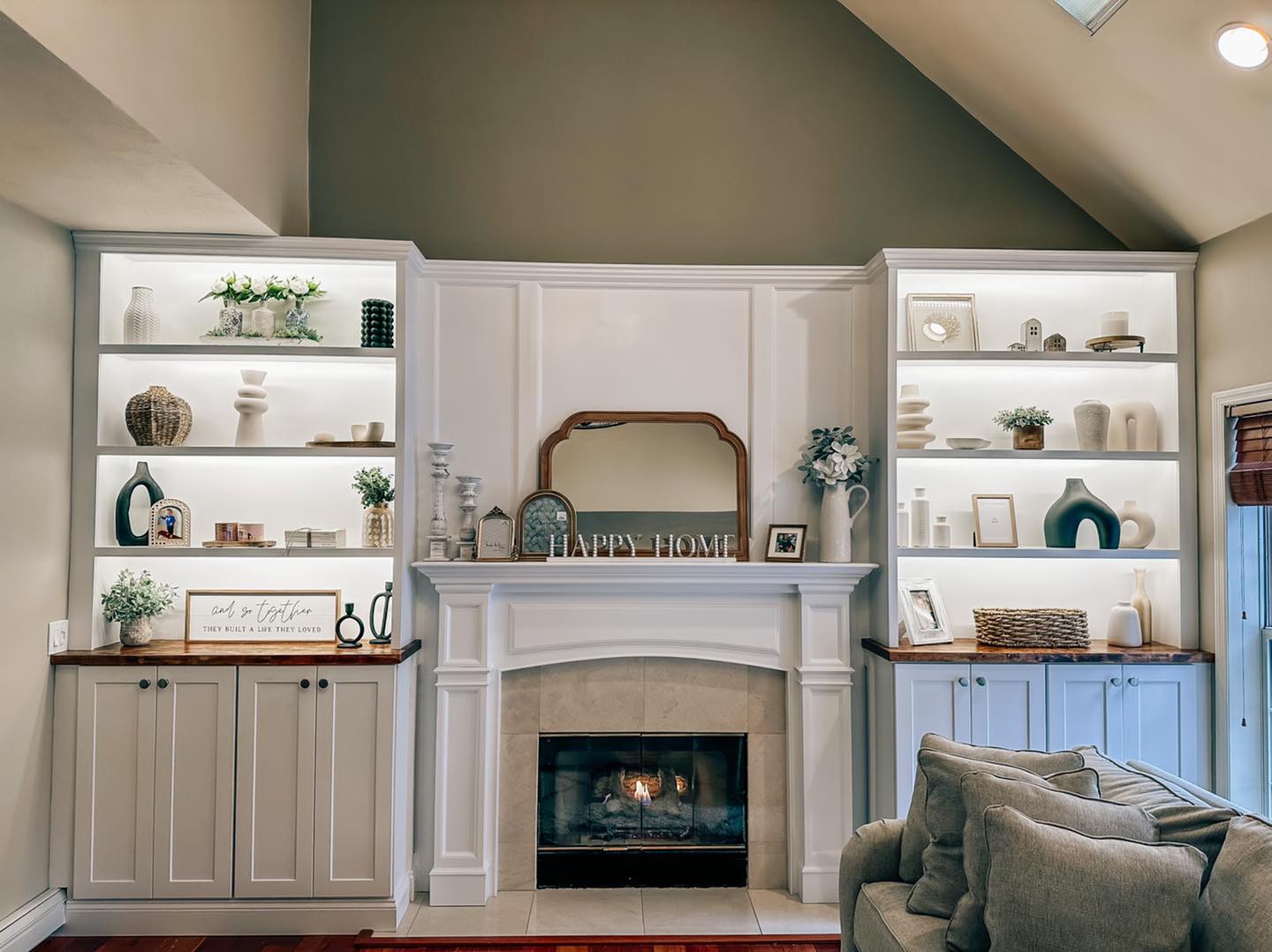 Custom millwork living room with built-in shelving, cabinetry, and fireplace surround
