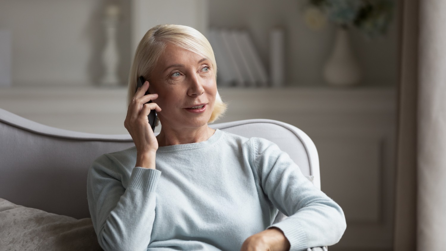 Woman talking on a phone while seated on a couc