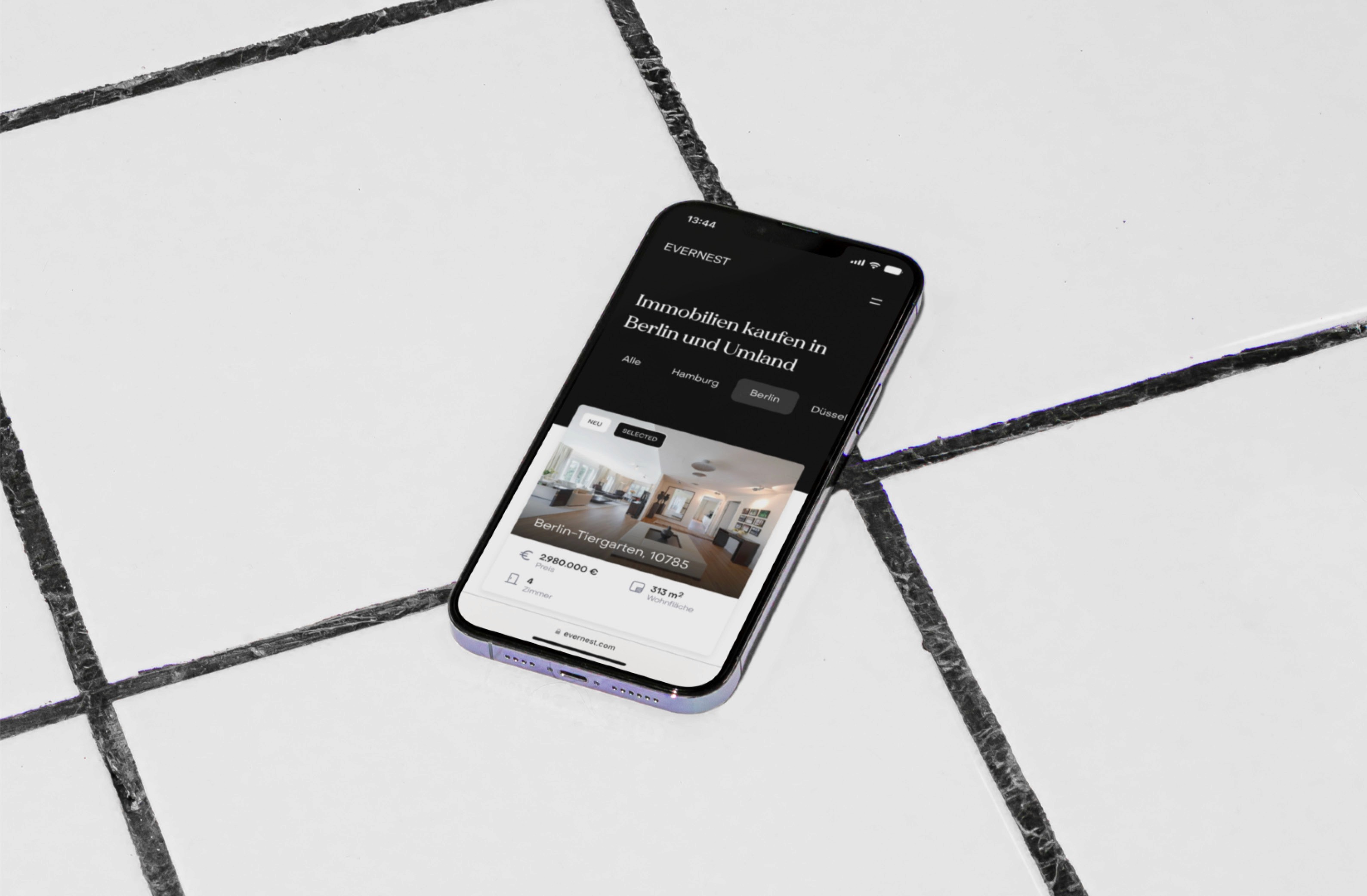 This image shows a smartphone displaying a real estate app focused on buying properties in Berlin and surrounding areas.