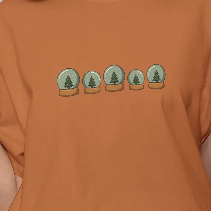 Five painted snow globes on a yam-orange tee
