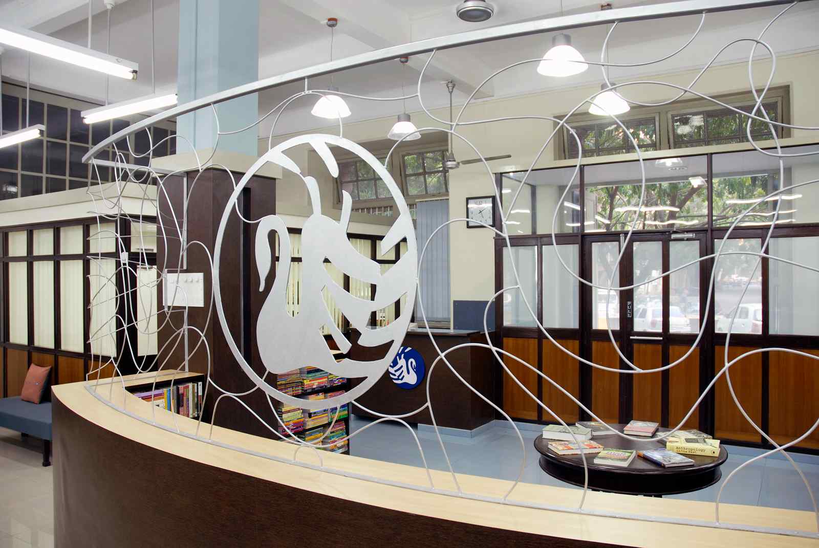 Nature-inspired preschool entrance with sculptural tree partitions and suspended green leaf ceiling panels.