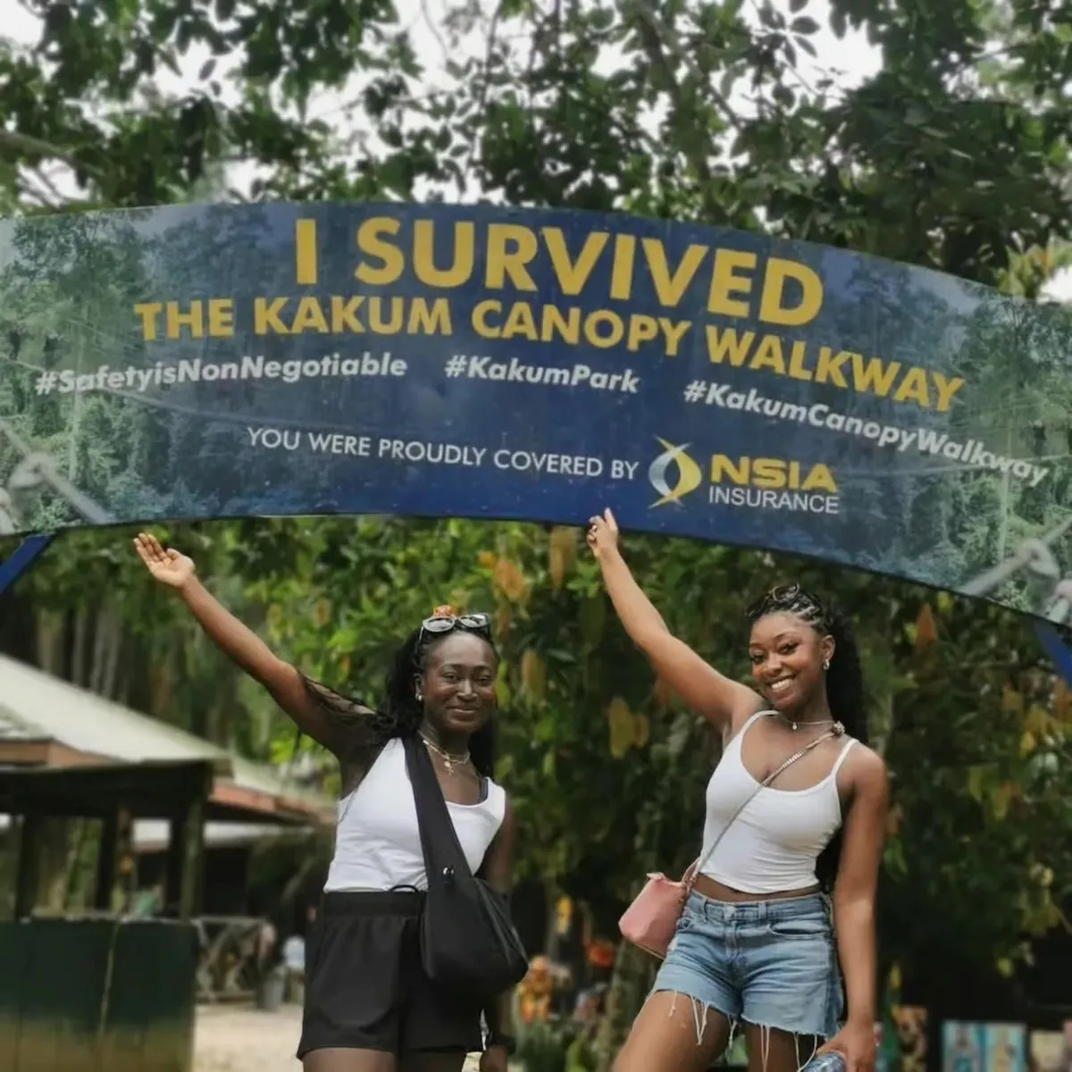 Two travelers celebrate completing the Kakum Canopy Walkway. 