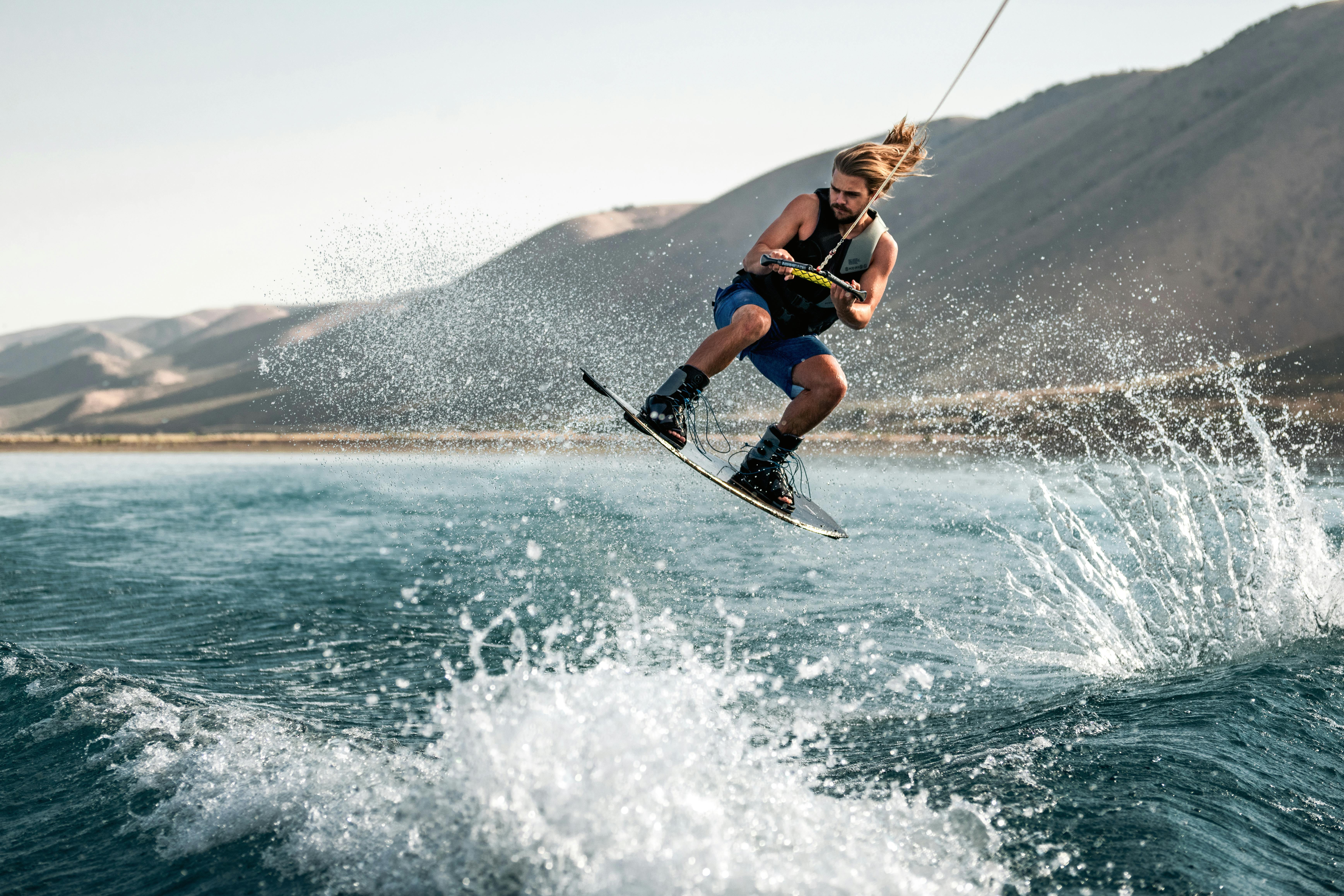 A man glides expertly across the waves on a wakeboard.