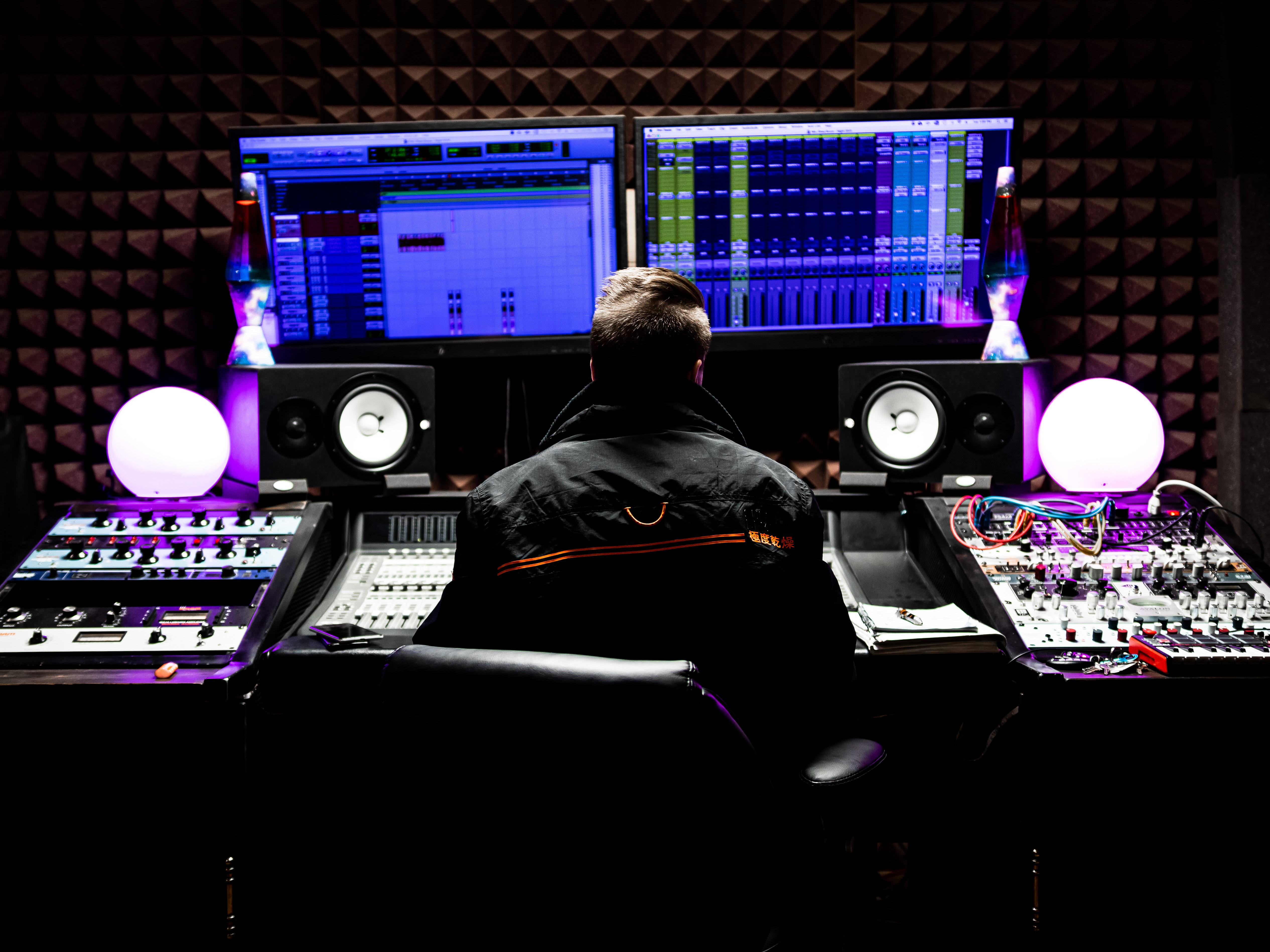 woman sitting infront of his PC and mic to create music - Music LM