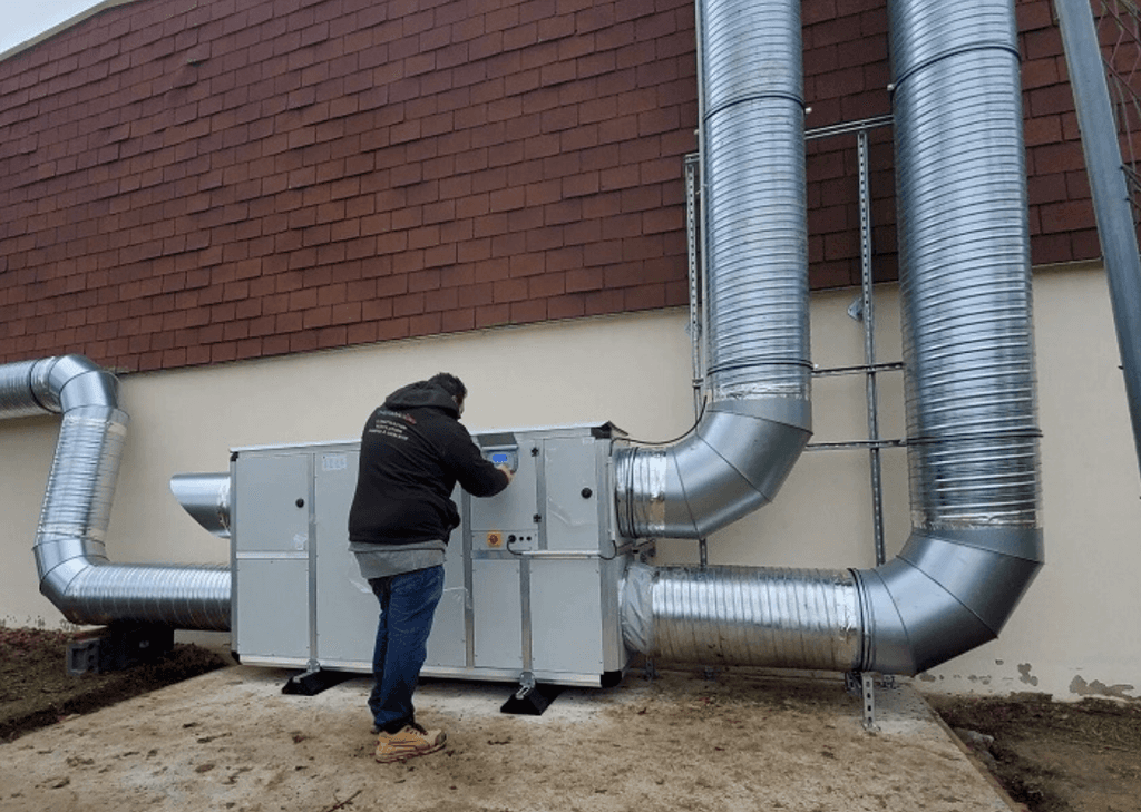 Le chef d'entreprise de ThermaClima en train de contrôler une climatisation sur la façade d'une maison située en banlieue de Nancy