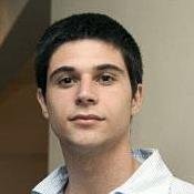 man sitting on gray concrete wall