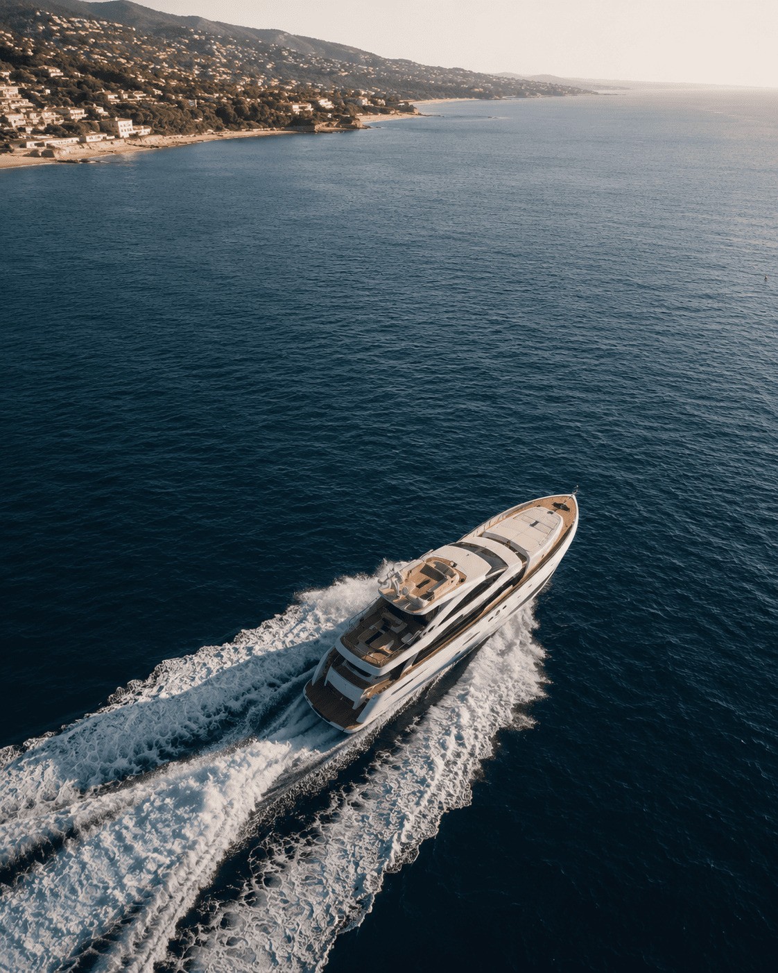 Large luxury yacht navigating the blue sea near high-end residential coastal areas in Maresme, Barcelona, showcasing premium Mediterranean living.