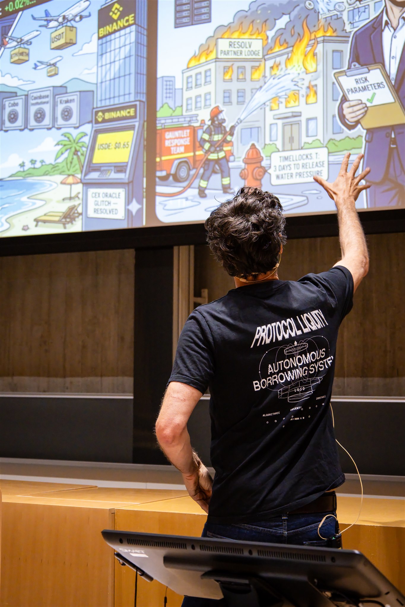 Speaker pointing at presentation screen during EthereumZüri conference talk