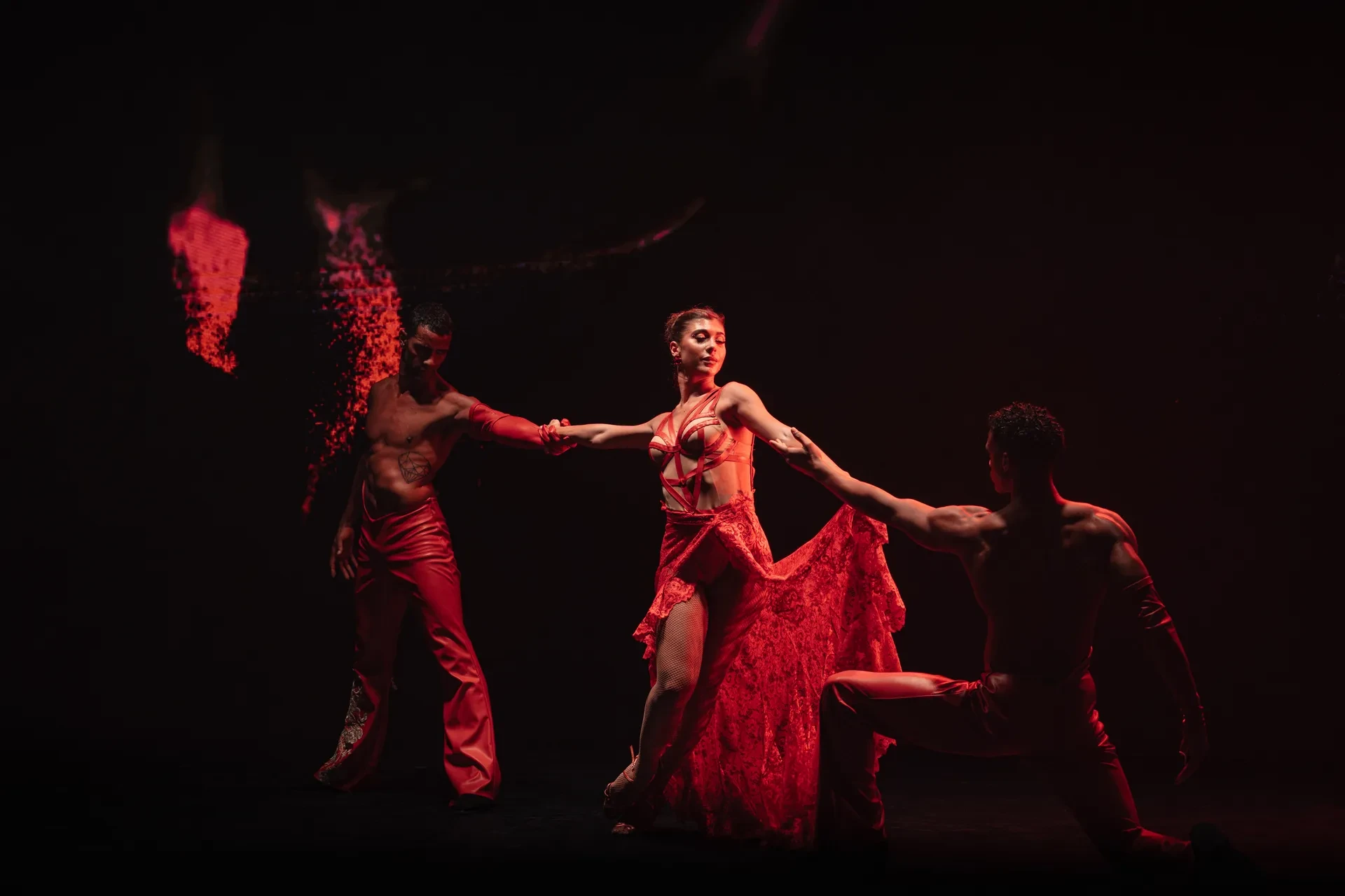 Dancers in red performing under dramatic stage lighting at Billionaire Dubai