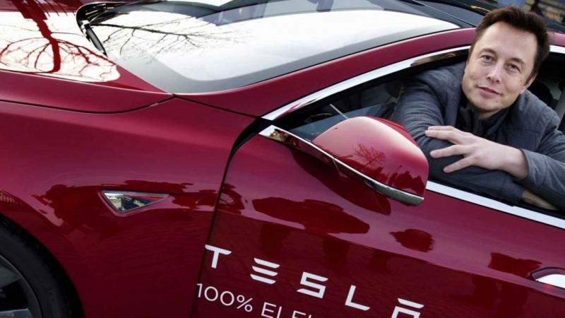 Elon Musk in an early model Tesla car