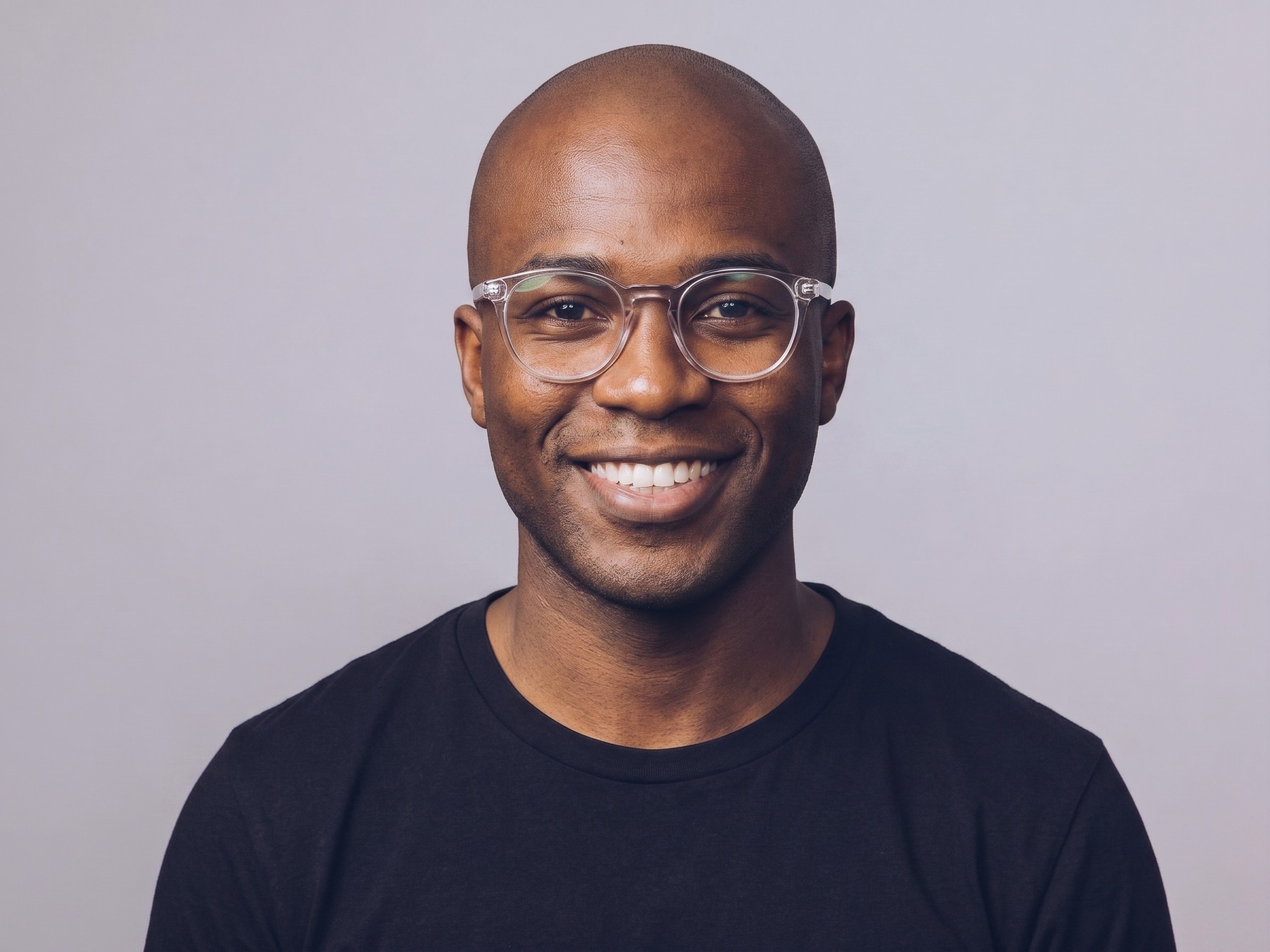 A person with glasses and a black shirt smiling.