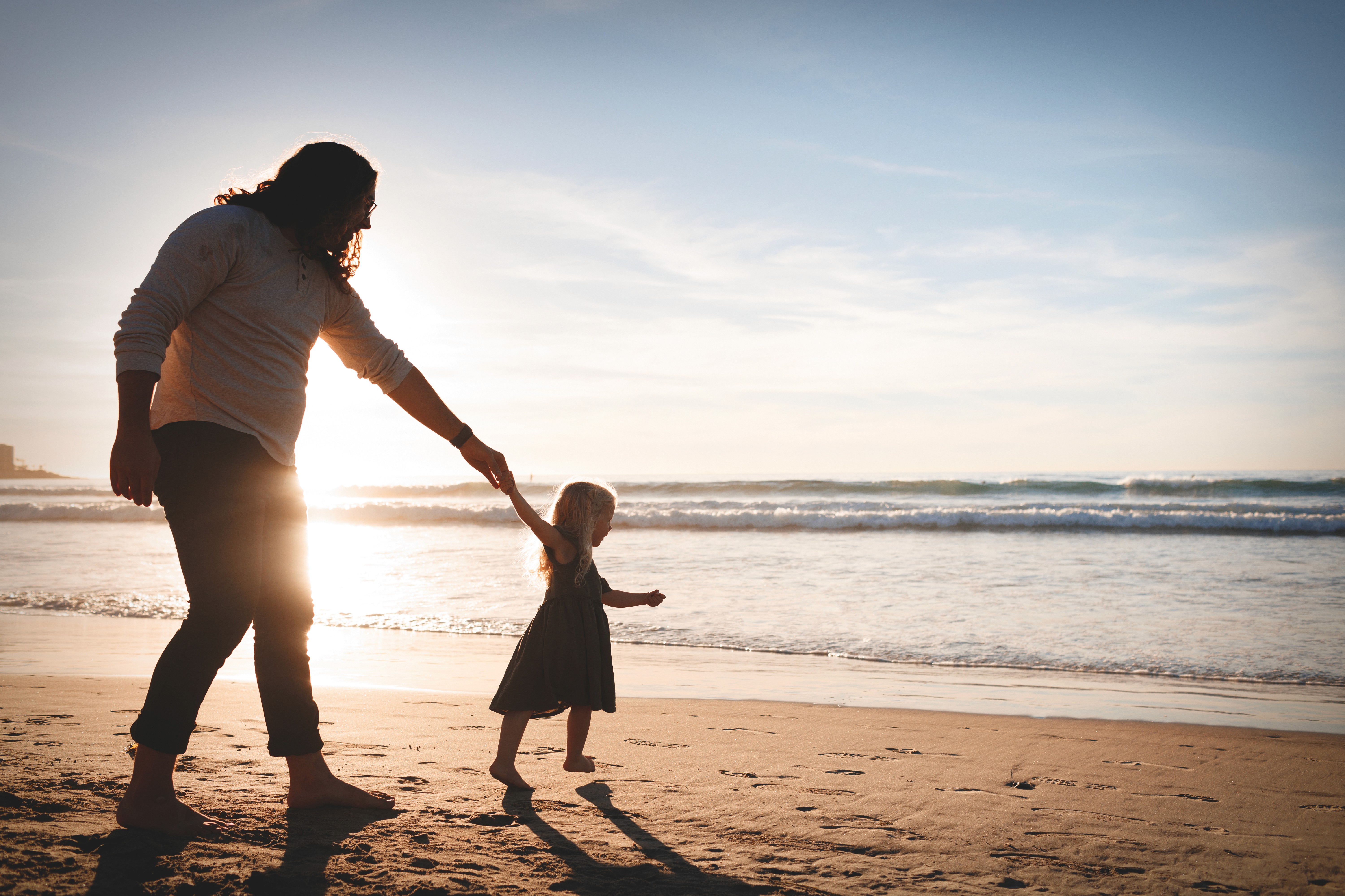 Dad holding daughter during sunset beach photoshoot