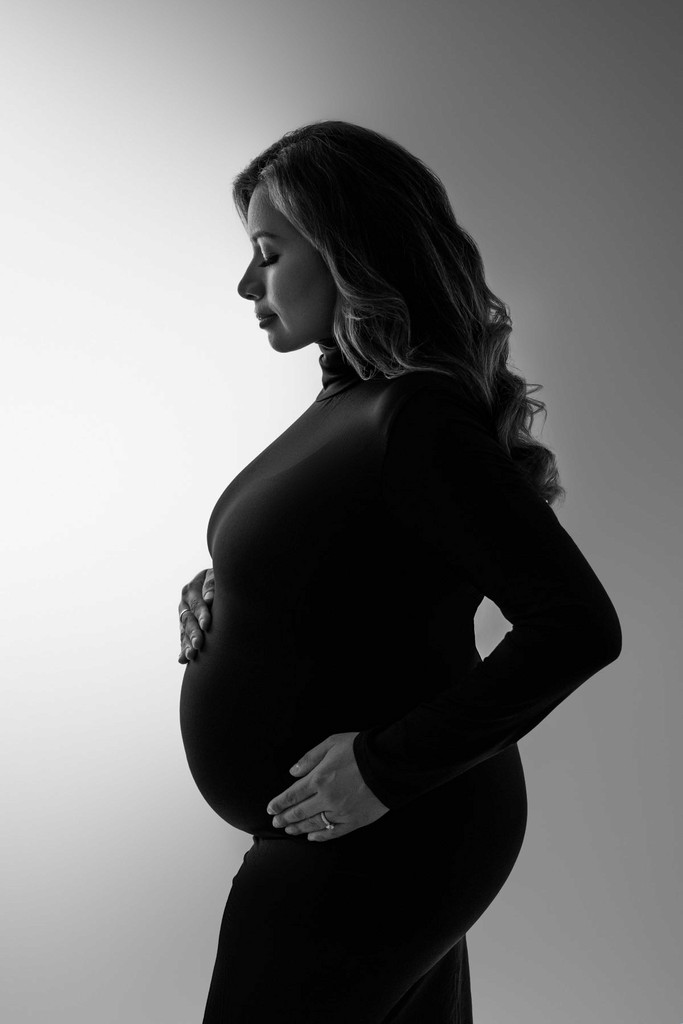 Expecting mom in simple fitted dress — timeless and modern maternity portrait.
