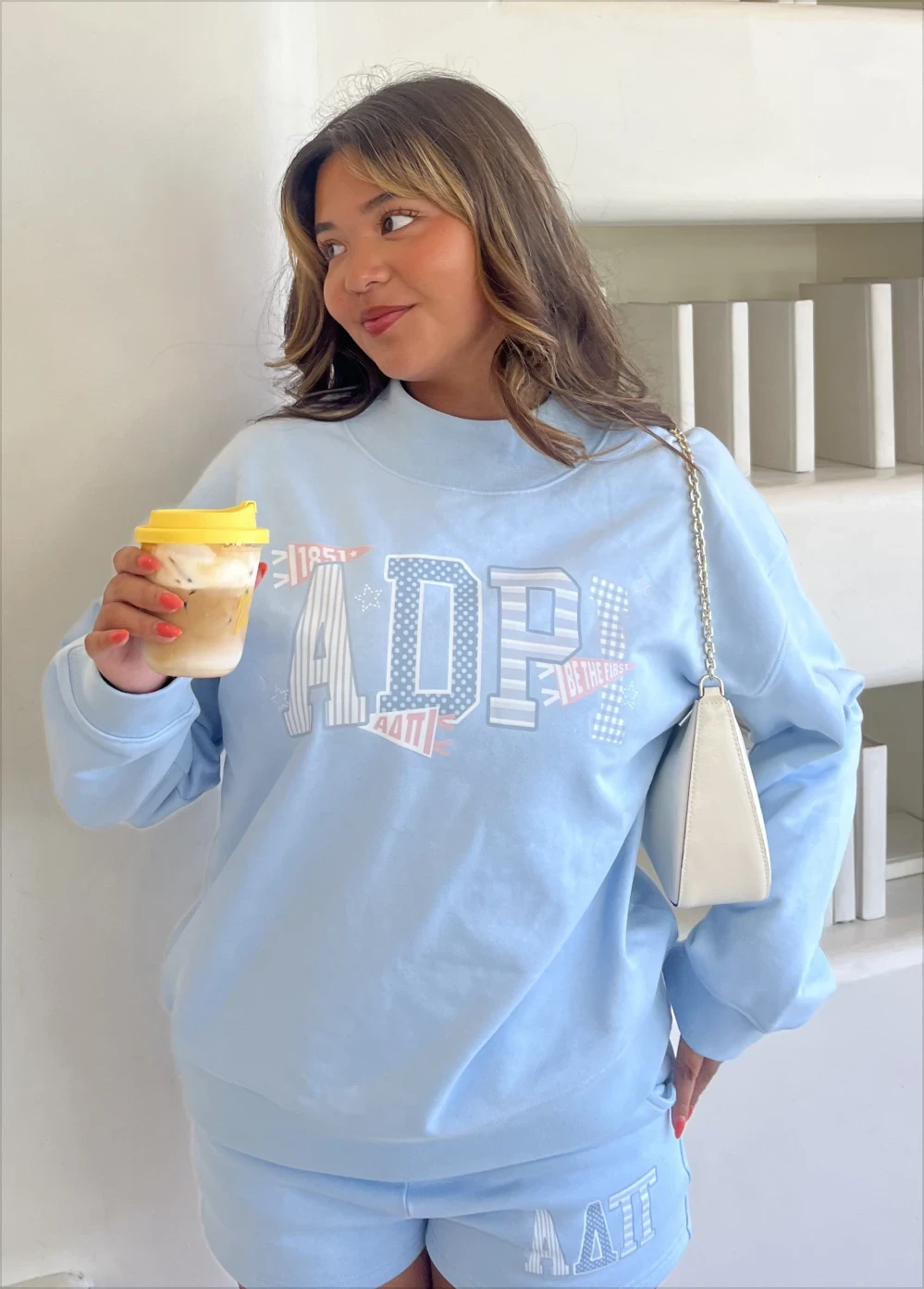 Clarissa, wearing a blue sorority set combining multiple shades and patterns.