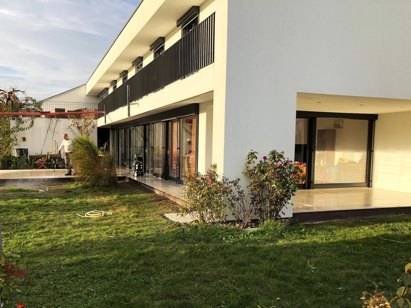 Erneuerte Umgebung mit moderner, erhöhter Terrasse aus Gartenplatten.