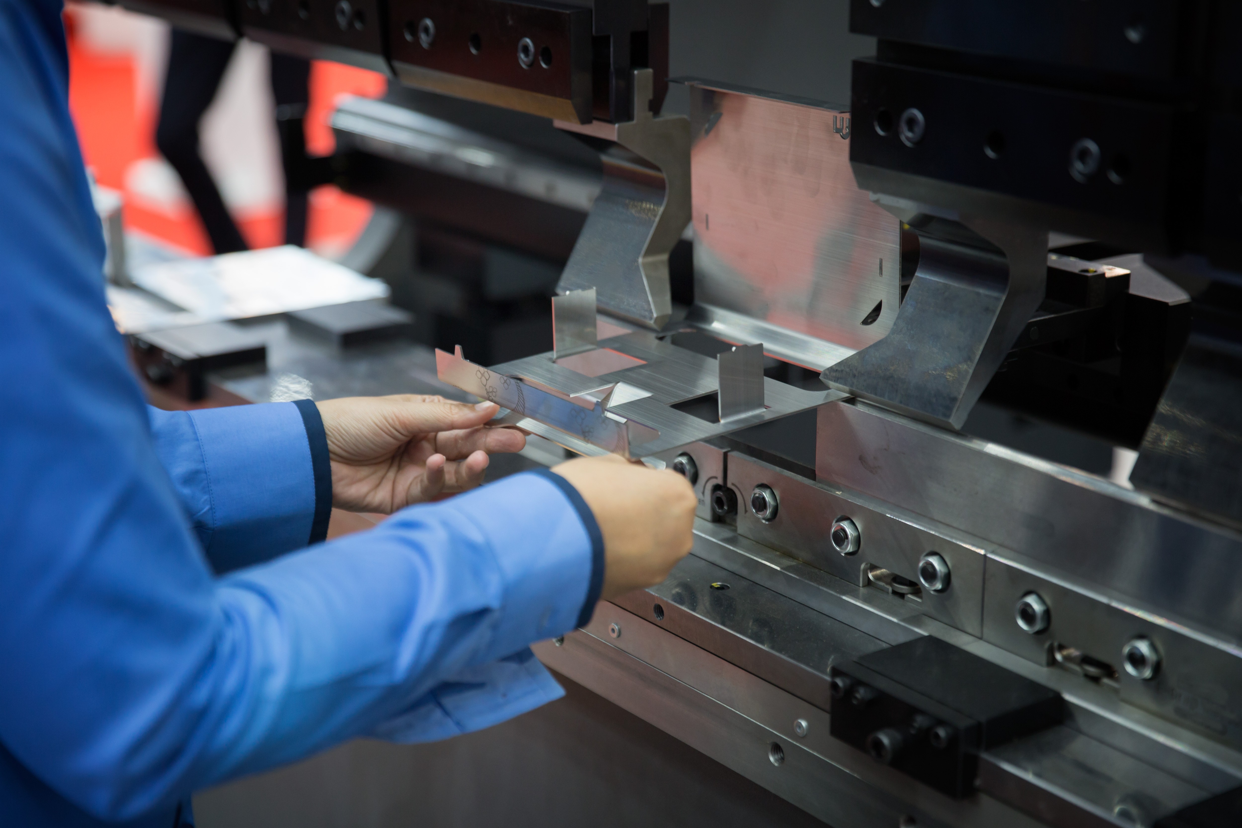 An operator meticulously preparing a metal sheet for the CNC machine by Automech