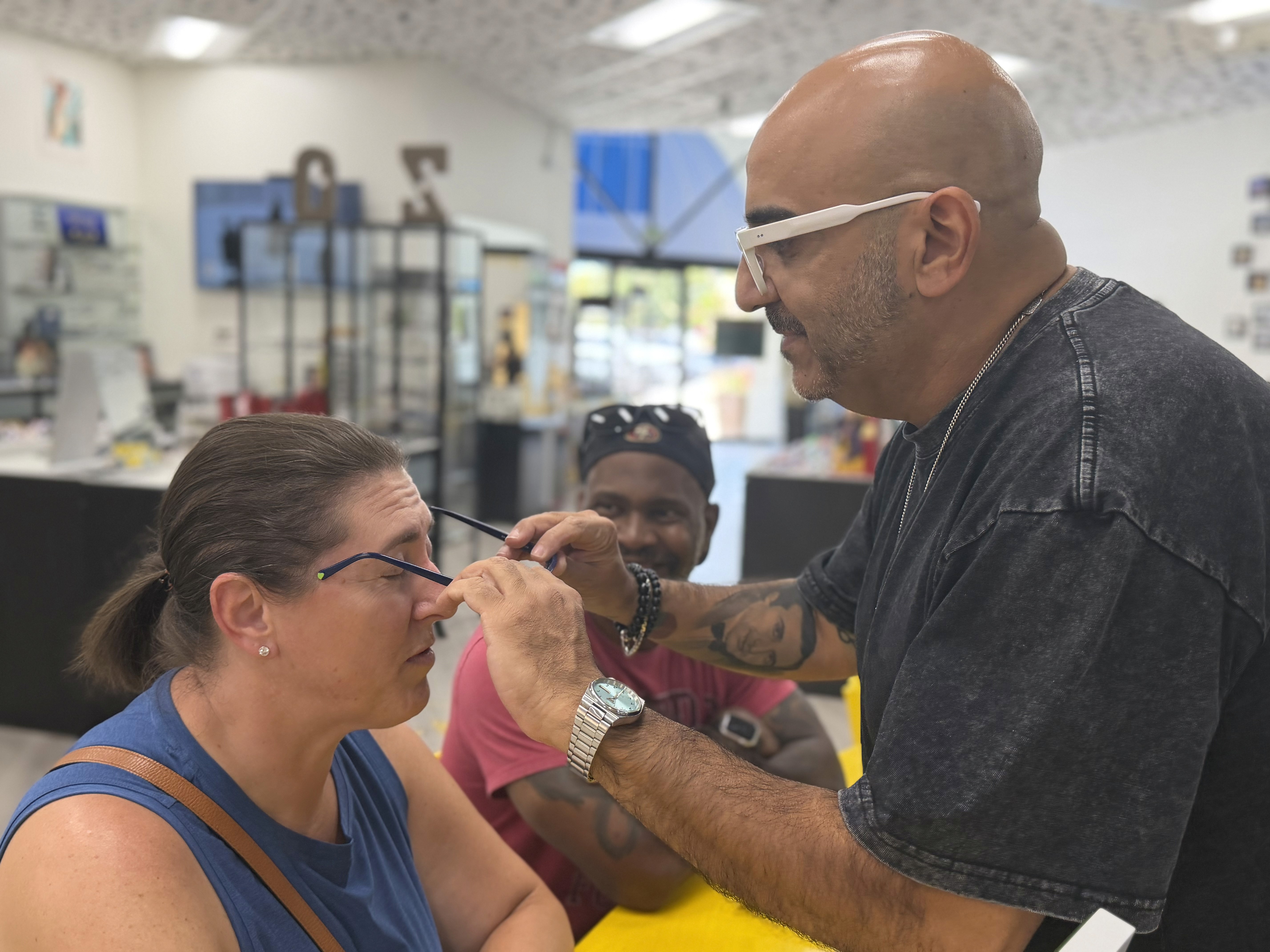 Serge helping a client try on glasses